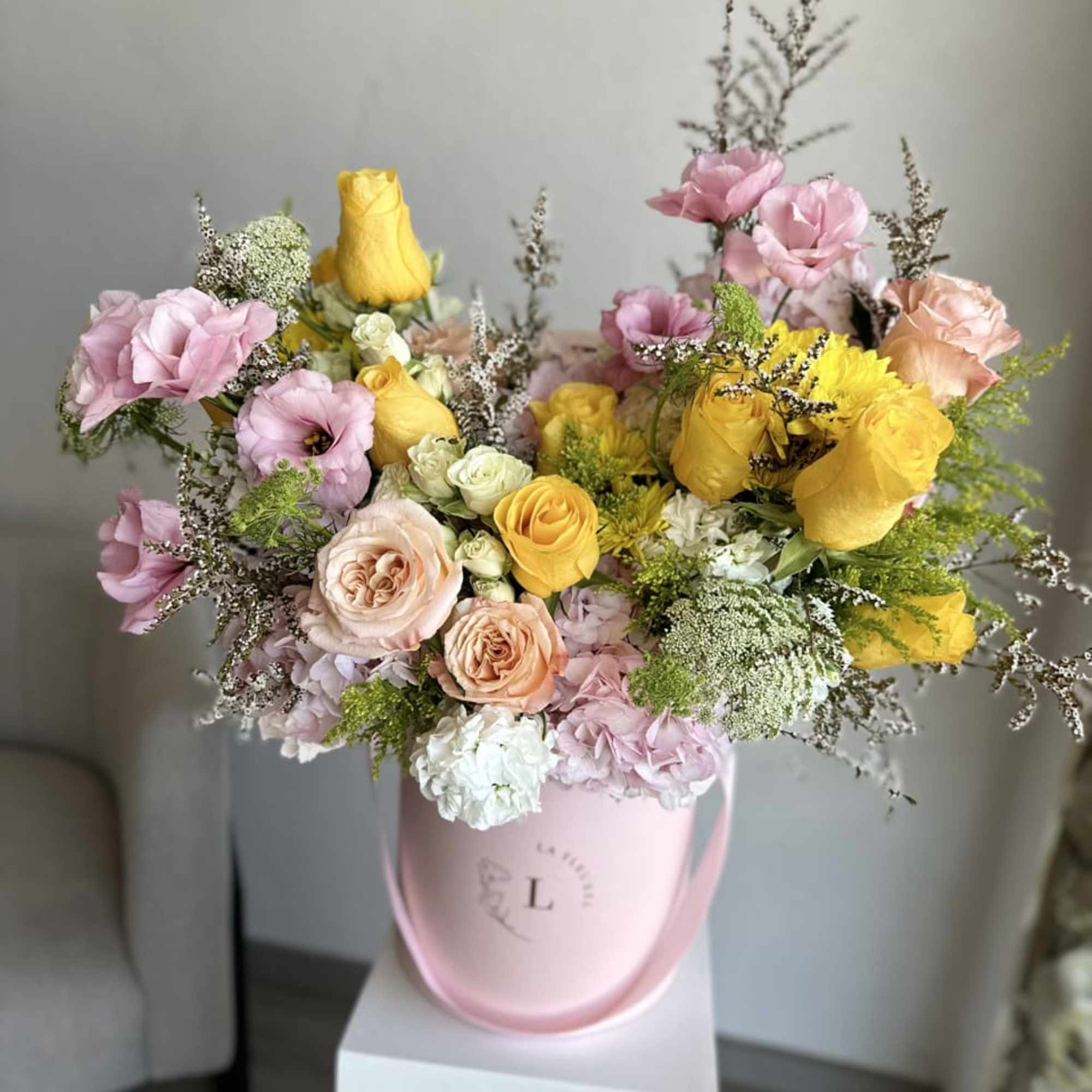 This beautiful arrangement filled with the yellow and pink roses, hydrangeas, lisianthus