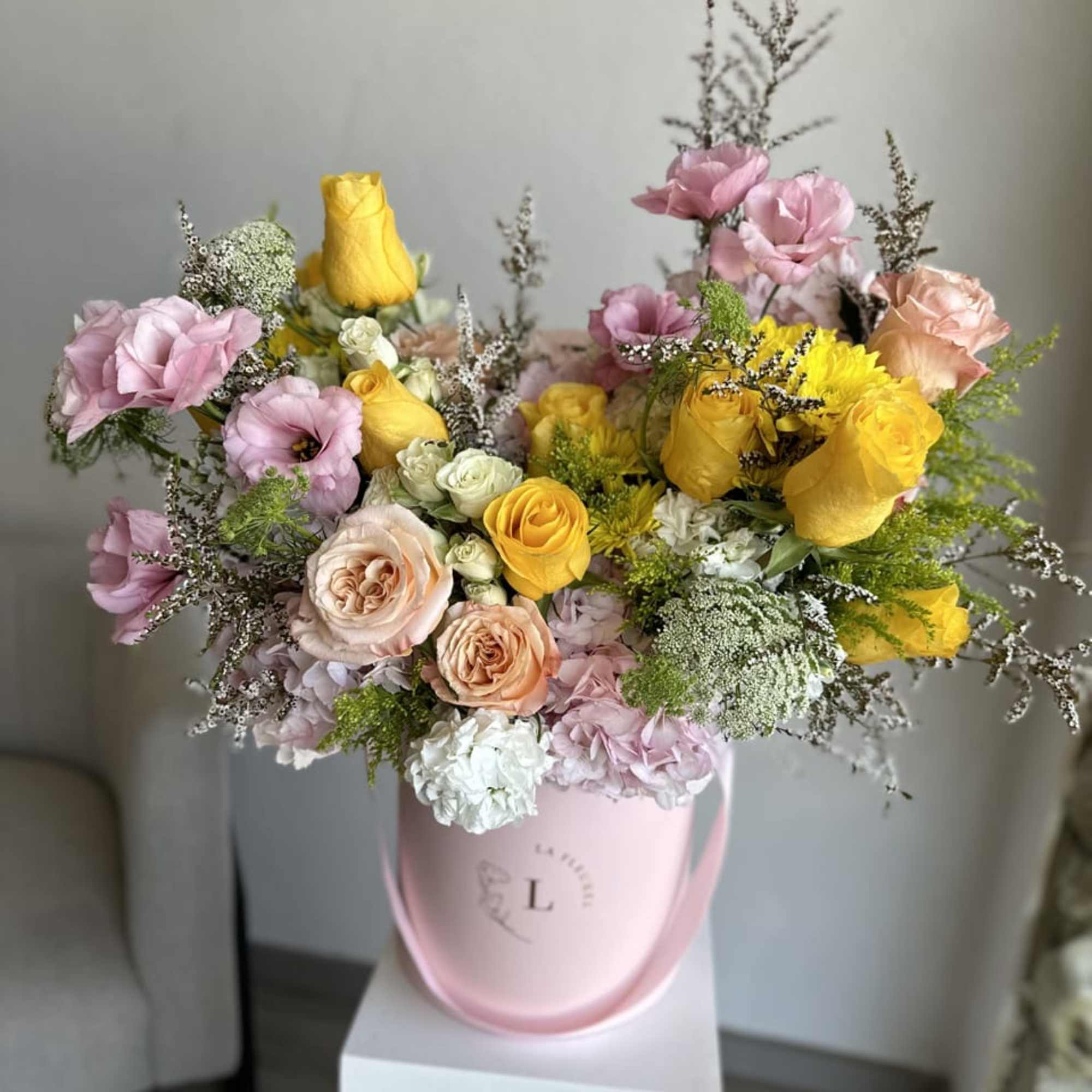 This beautiful arrangement filled with the yellow and pink roses, hydrangeas, lisianthus