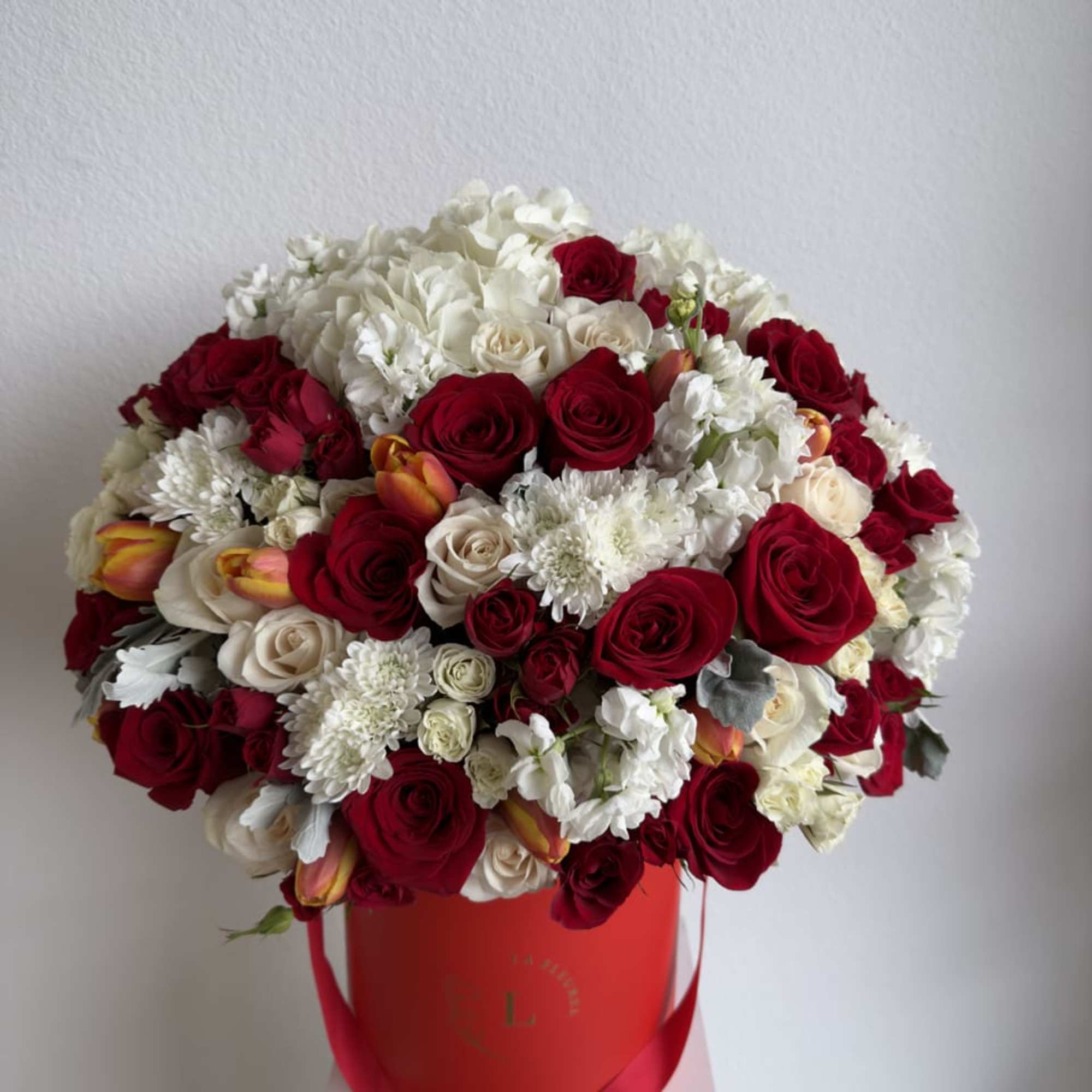 This beautiful arrangement is filled with red and white roses, spray roses