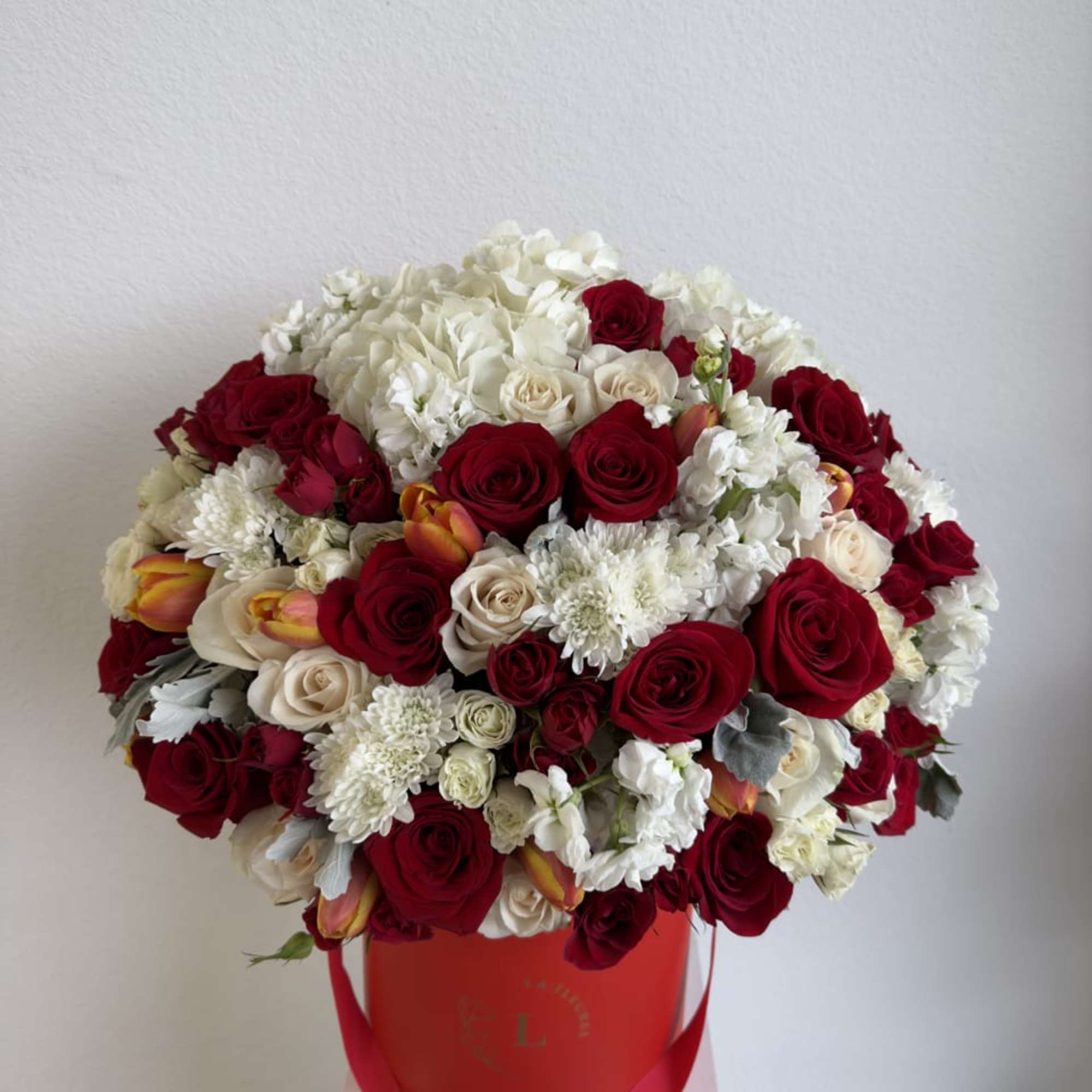 This beautiful arrangement is filled with red and white roses, spray roses