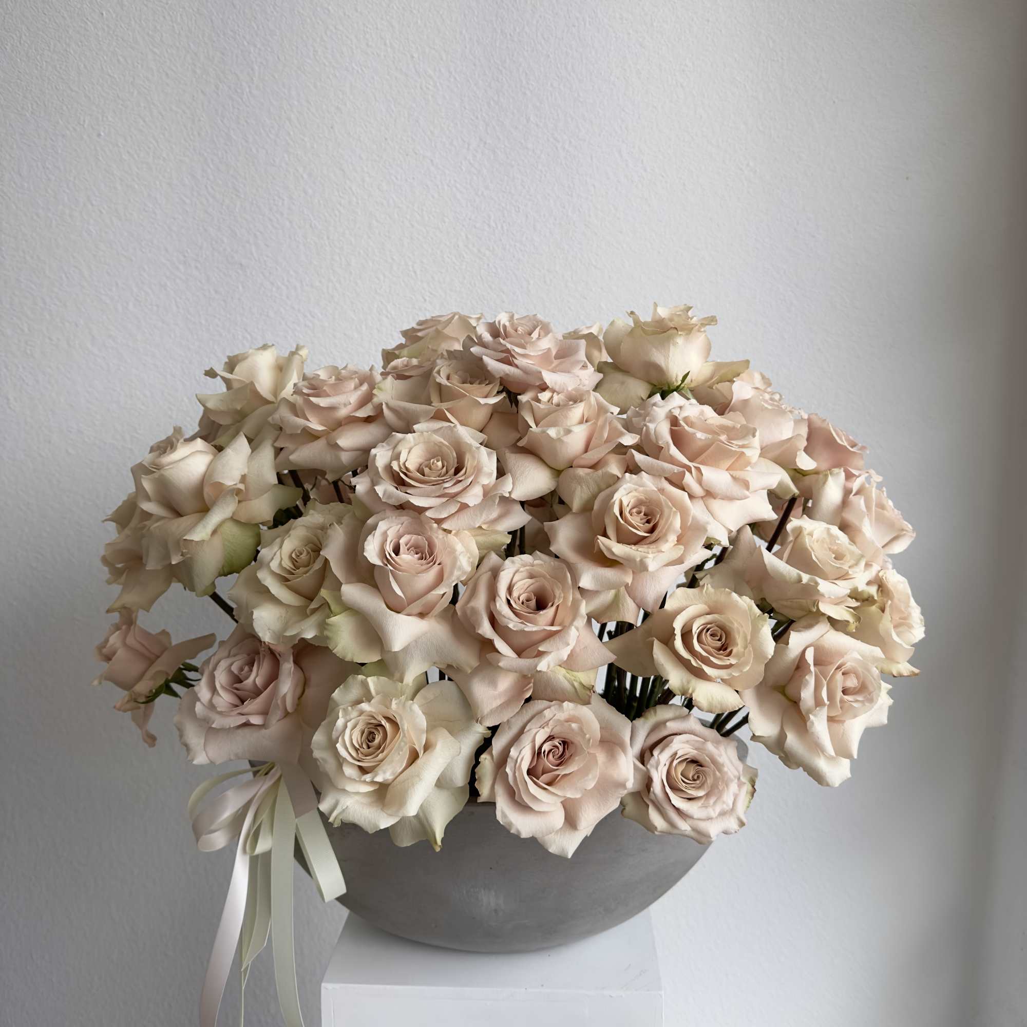 Our luxury arrangement of 50 quicksand roses in a beautiful concrete vase.

Arrangement