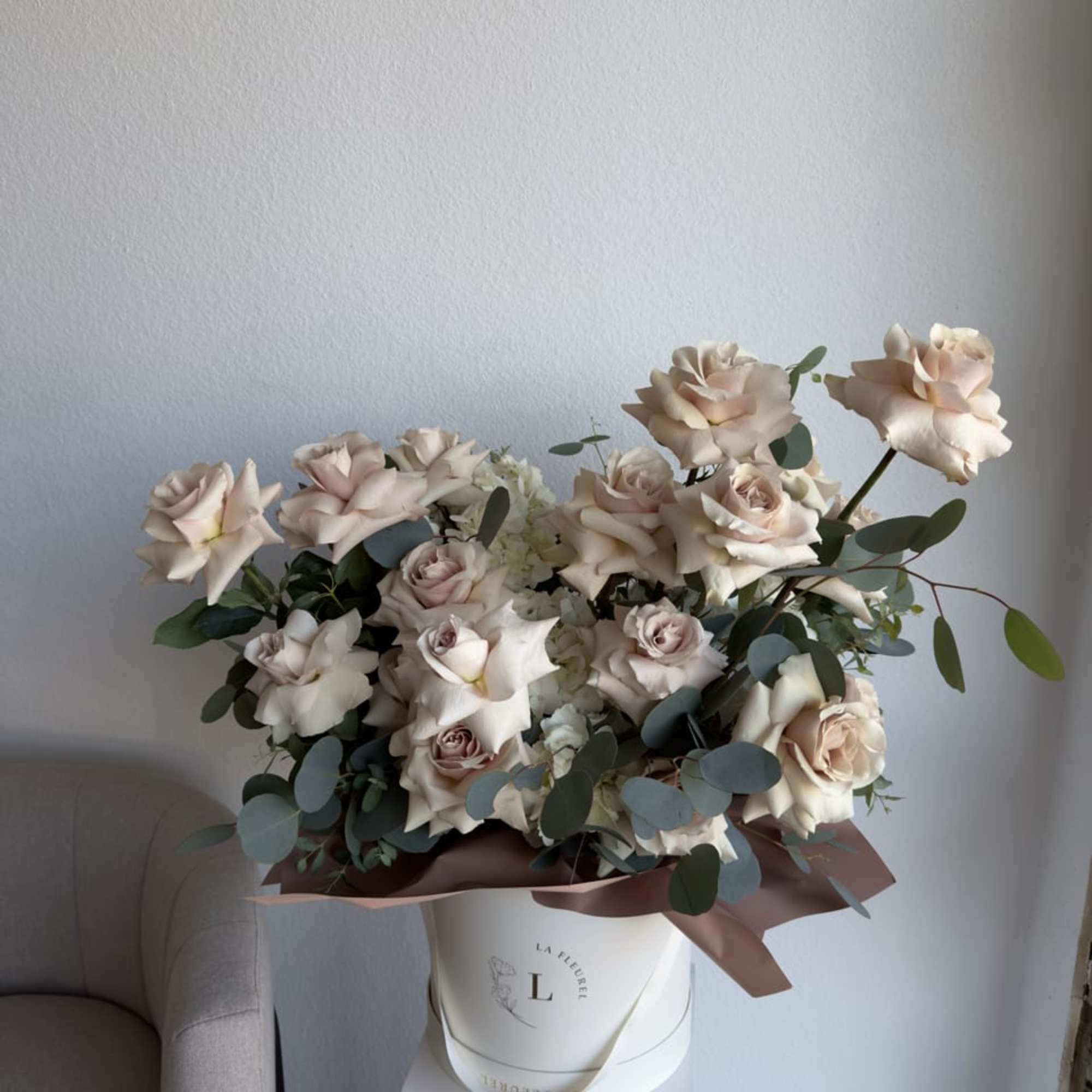 This beautiful arrangement is filled with beige color roses and greens to