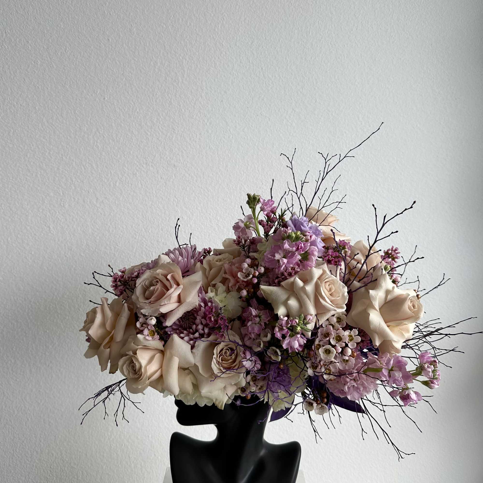 This beautiful arrangement is filled with beige roses, stock and greens to