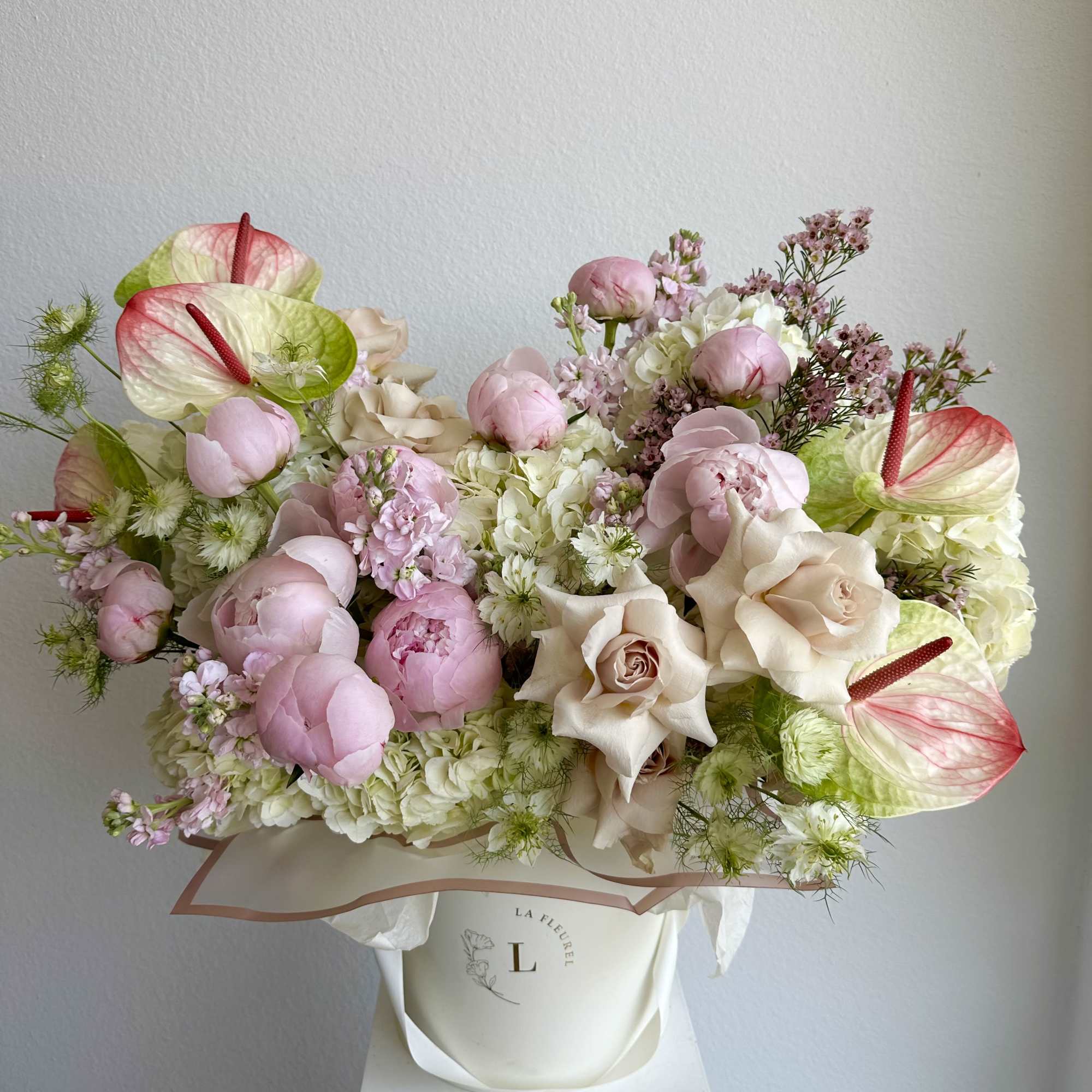 This romantic arrangement includes roses, hydrangeas, peonies, anthurium and greens.

Perfect for any