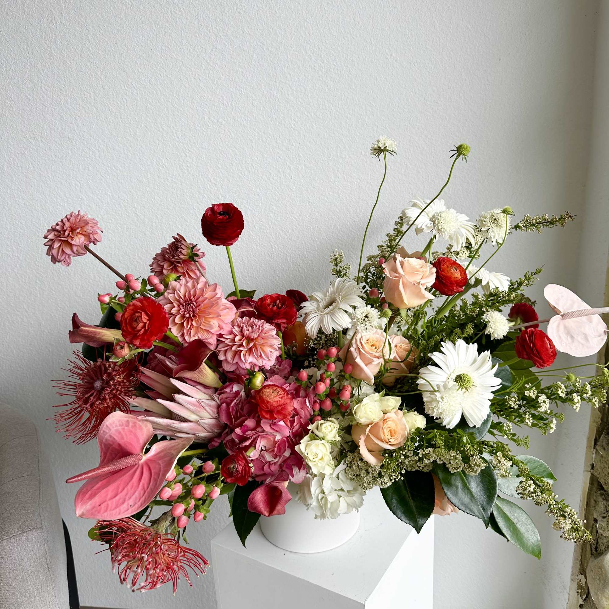 This beautiful arrangement is filled with red and peach roses, hydrangeas, dahlias