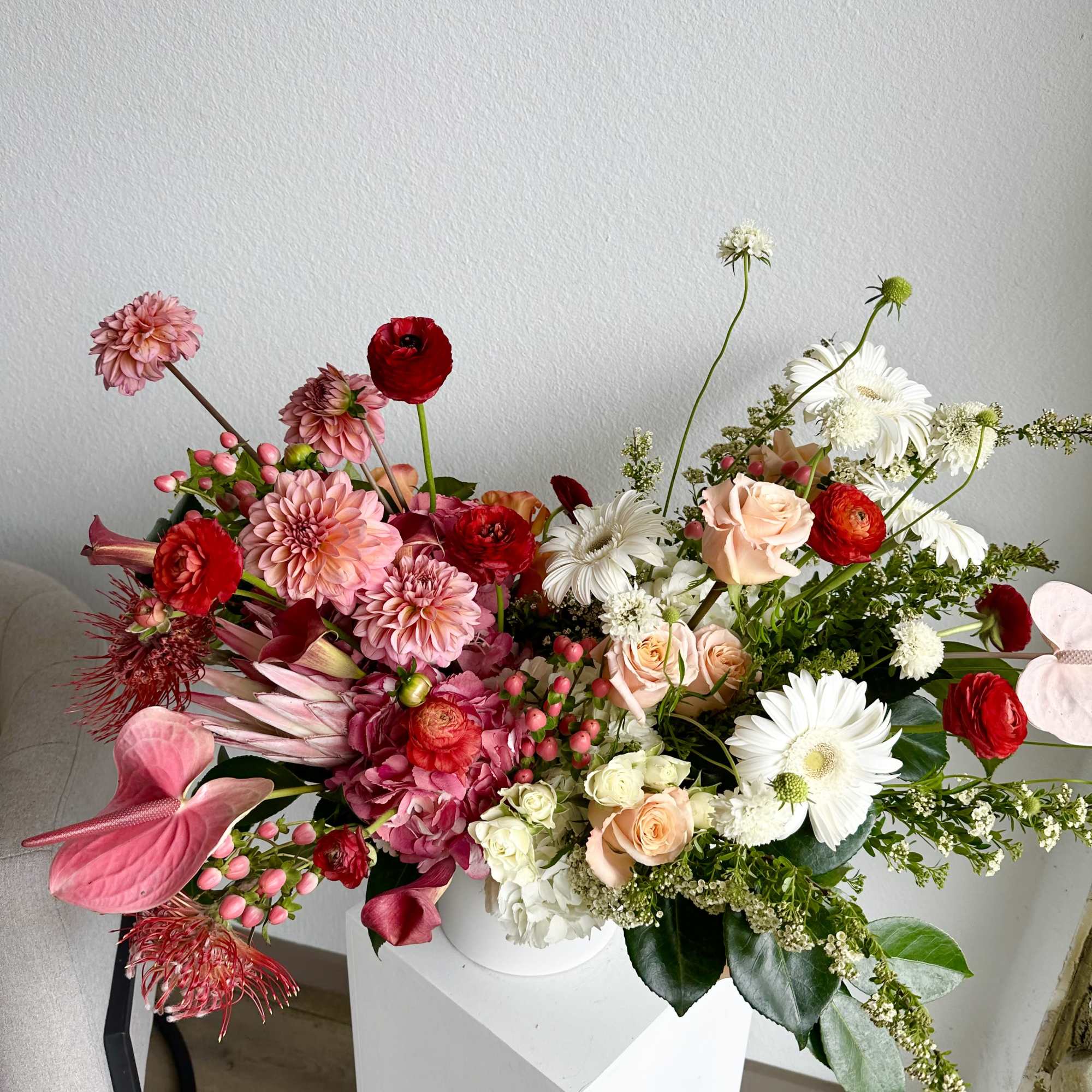 This beautiful arrangement is filled with red and peach roses, hydrangeas, dahlias