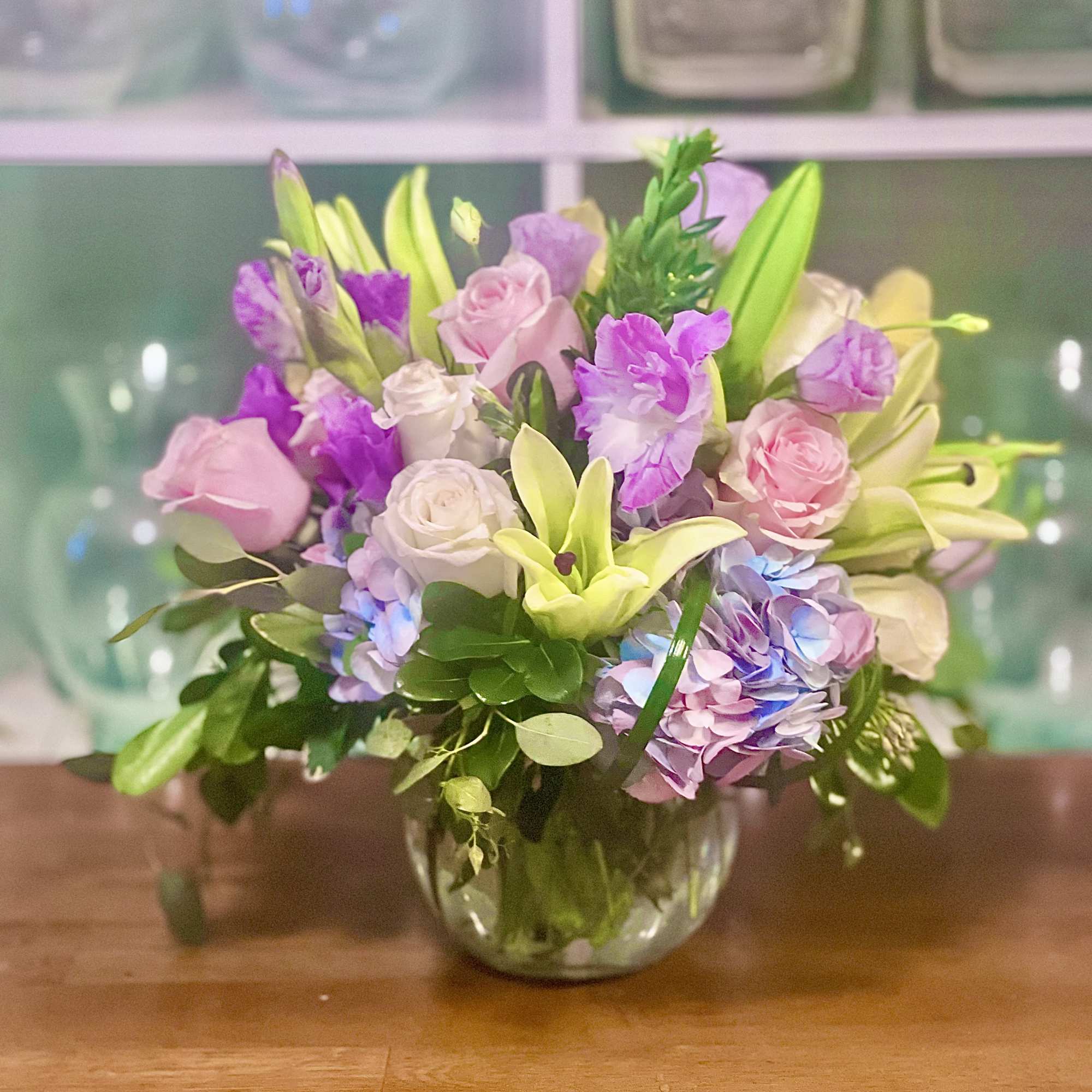 A beautiful pastel inspired arrangement of mixed flowers in a clear bubble