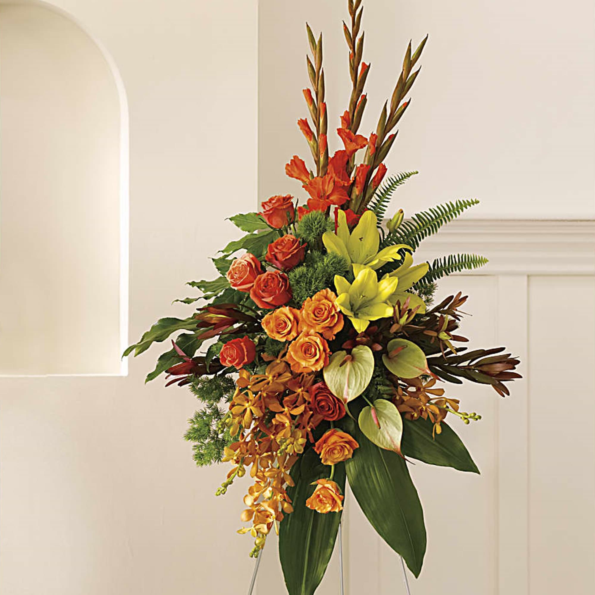 A graceful modern funeral spray of warm colors, it includes flowers such