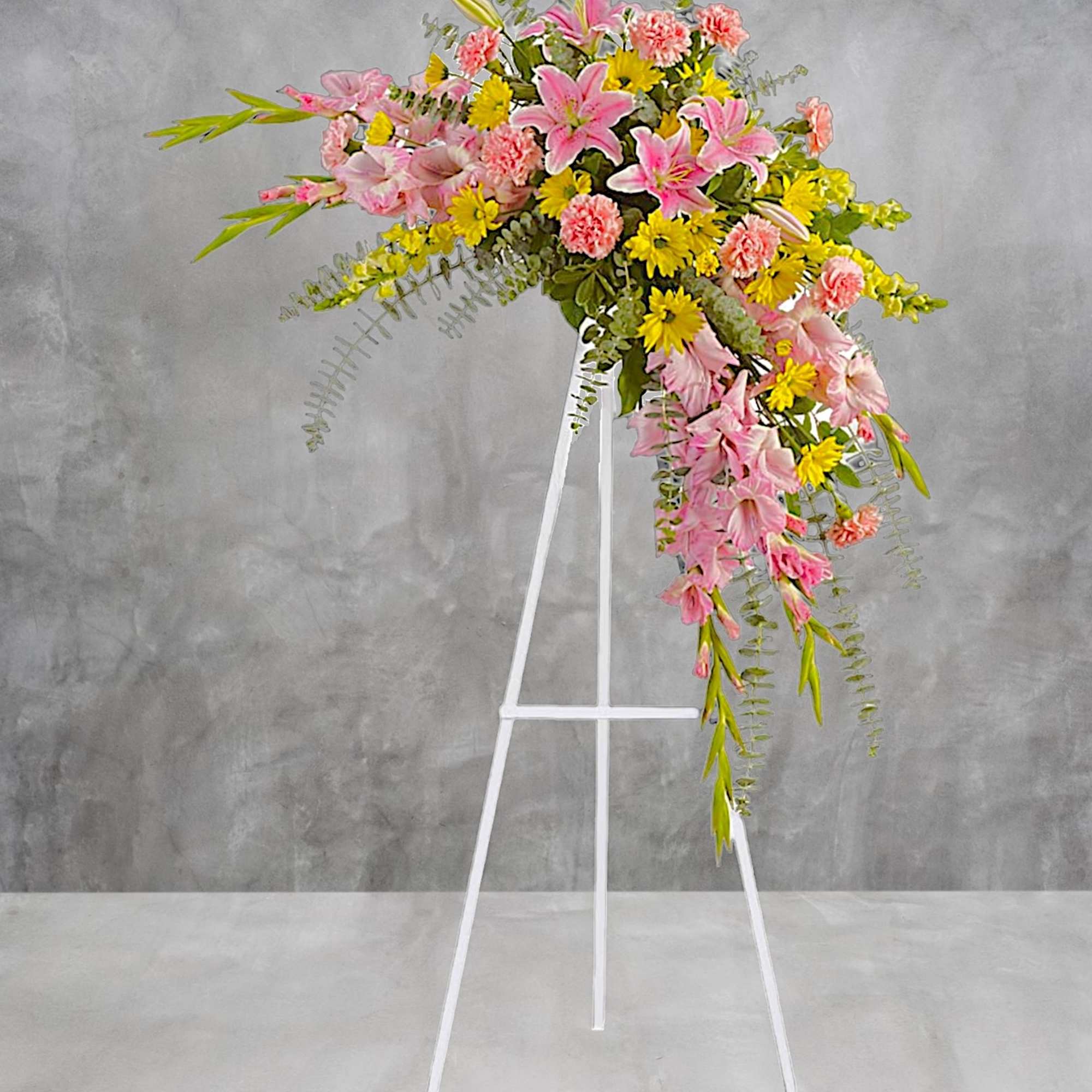 Soft, soothing pink lilies &amp; yellow daisies are crafted into a crescent