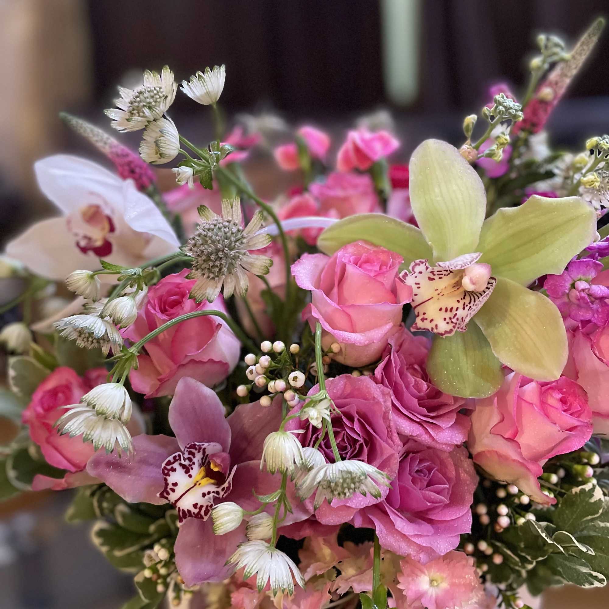 The combination of orchids and roses creates a dreamy and enchanting floral