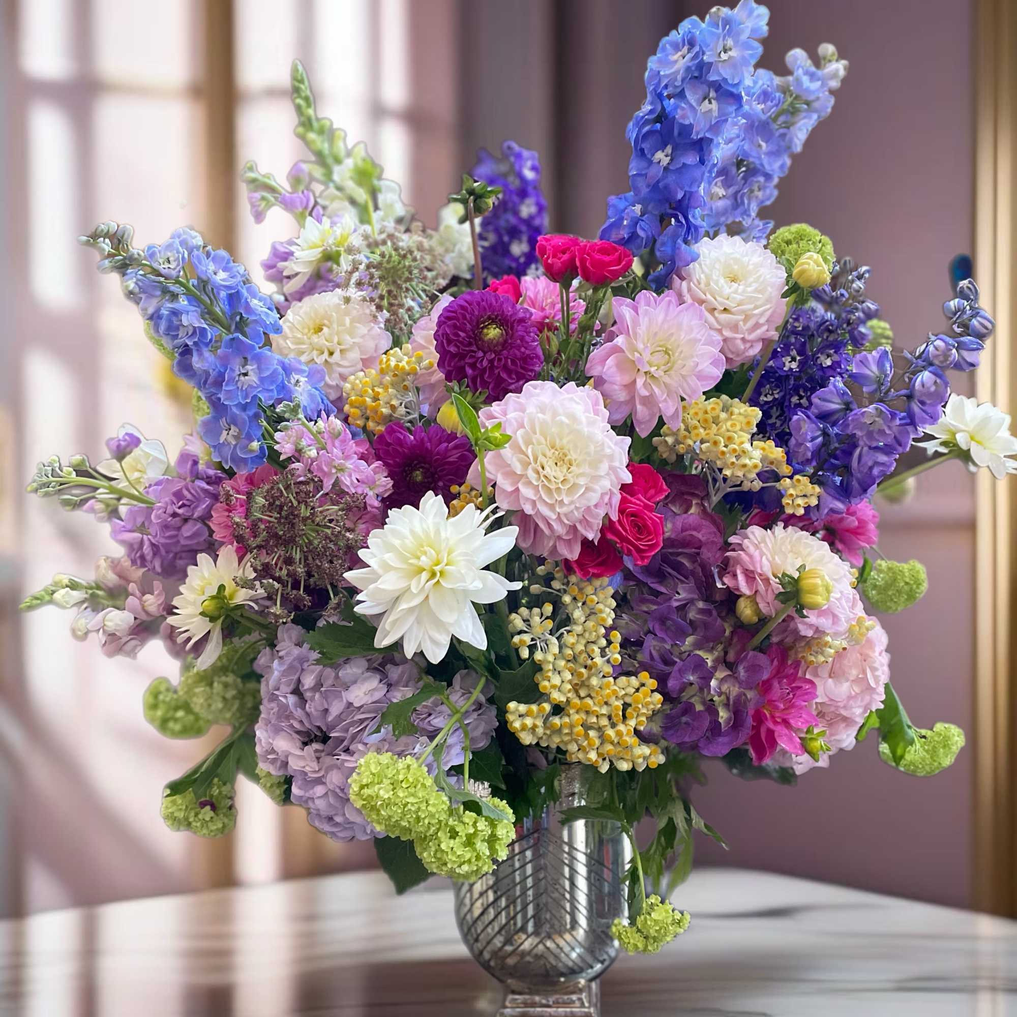 breathtaking floral arrangement featuring vibrant dahlias in deep burgundy and soft blush