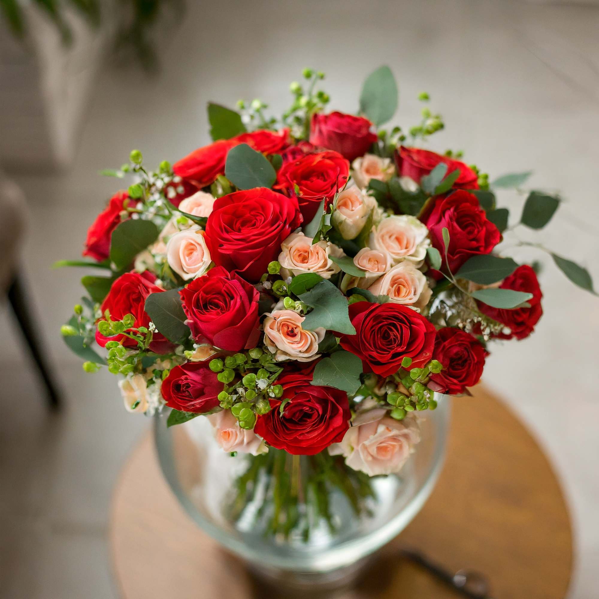 A charming and beautiful bouquet featuring red roses and cream spray roses