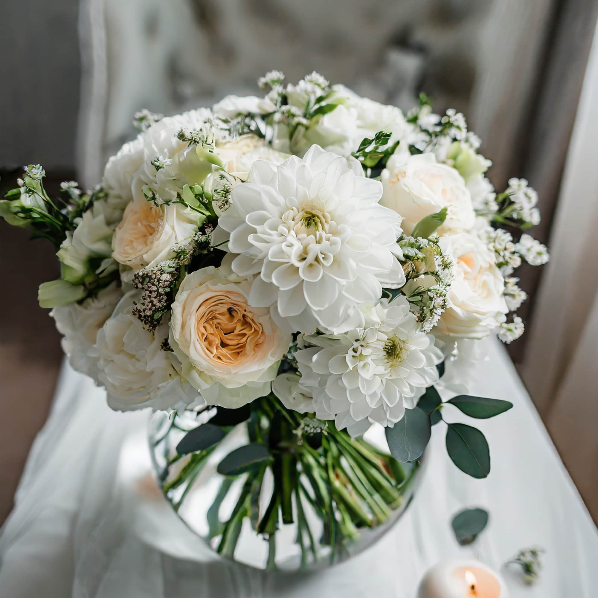 A charming and beautiful bouquet featuring ivory roses, white dahlias, and an
