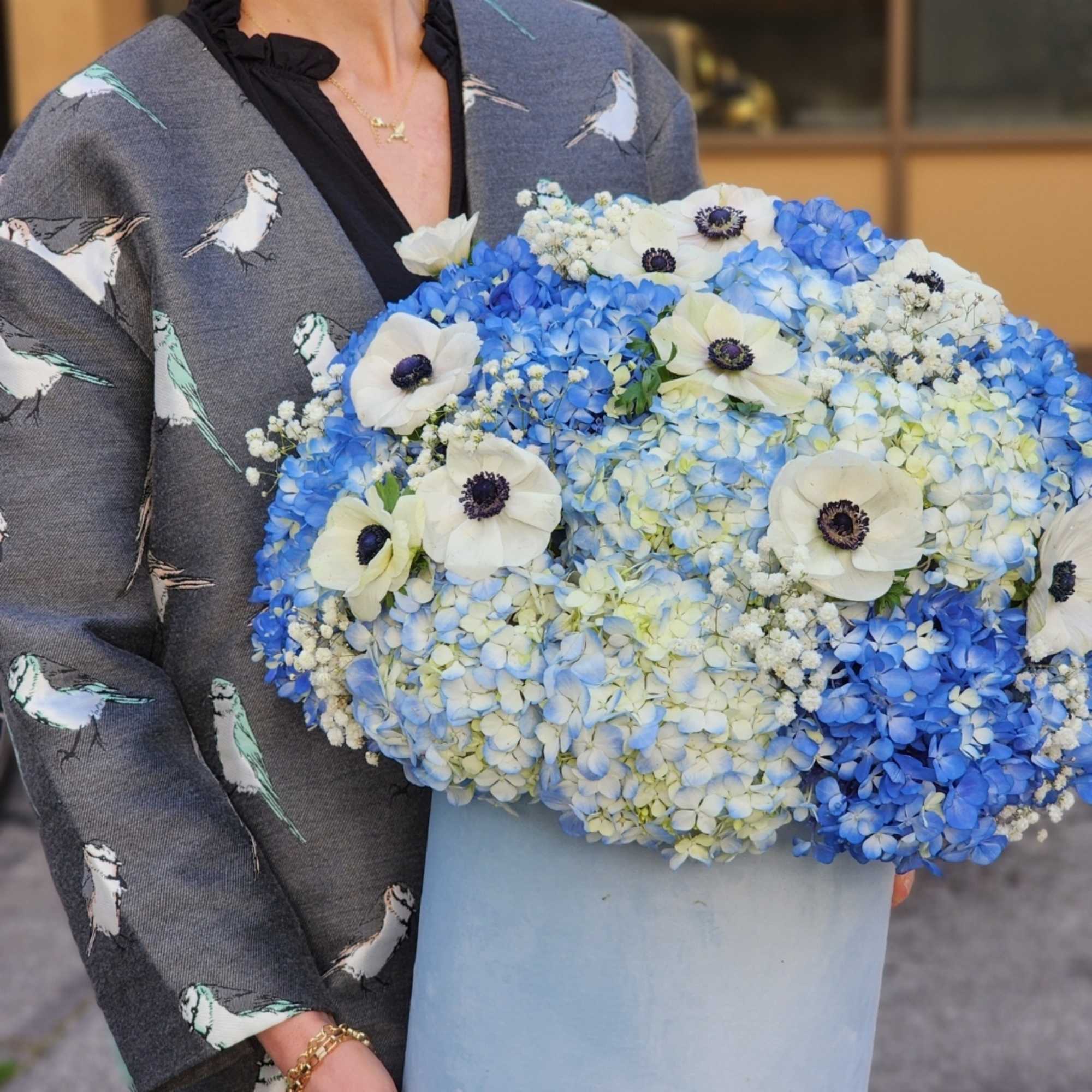 Stunning blue hydrangeas complemented by delicate anemones, all presented in an elegant