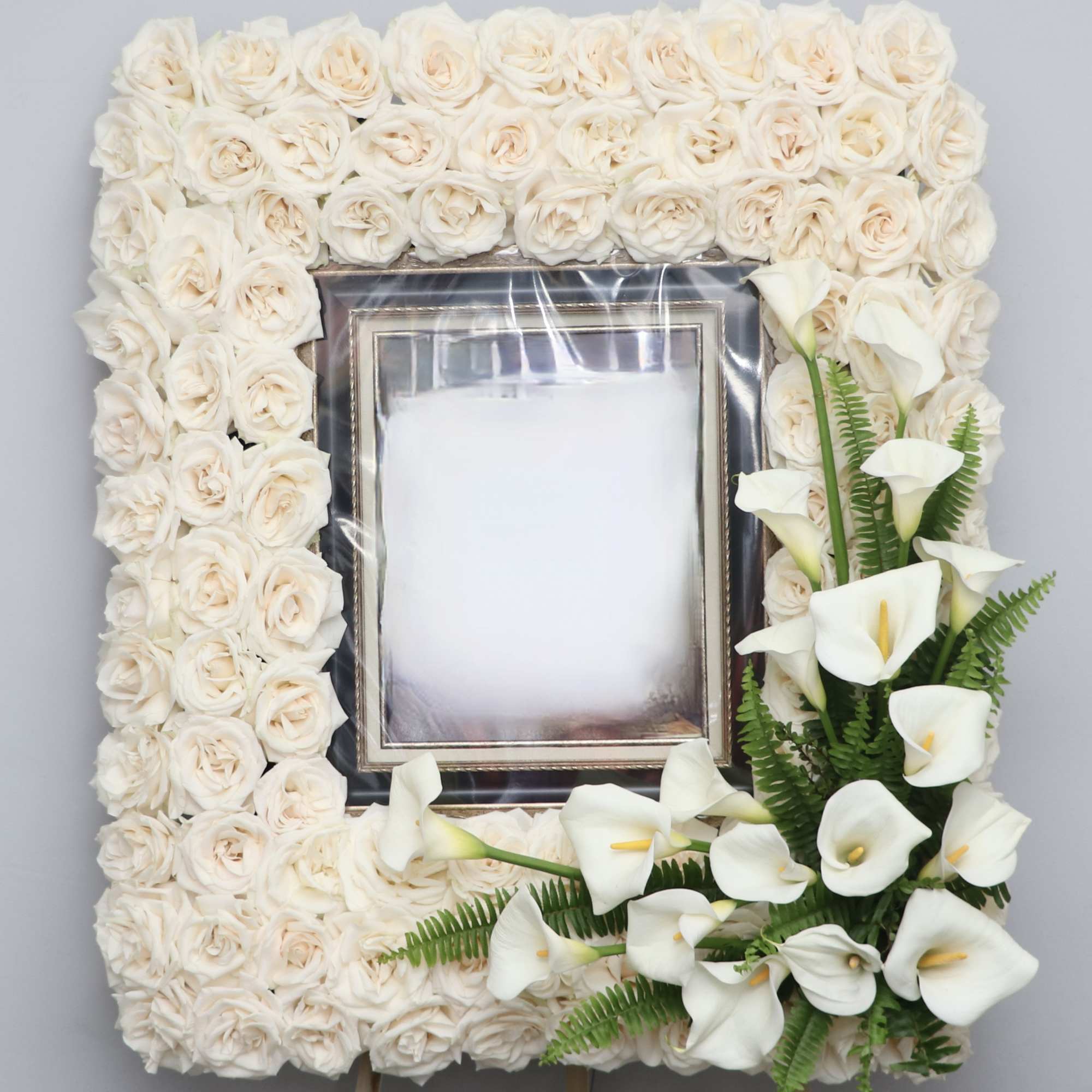 This beautiful sympathy frame is made with all white roses with a