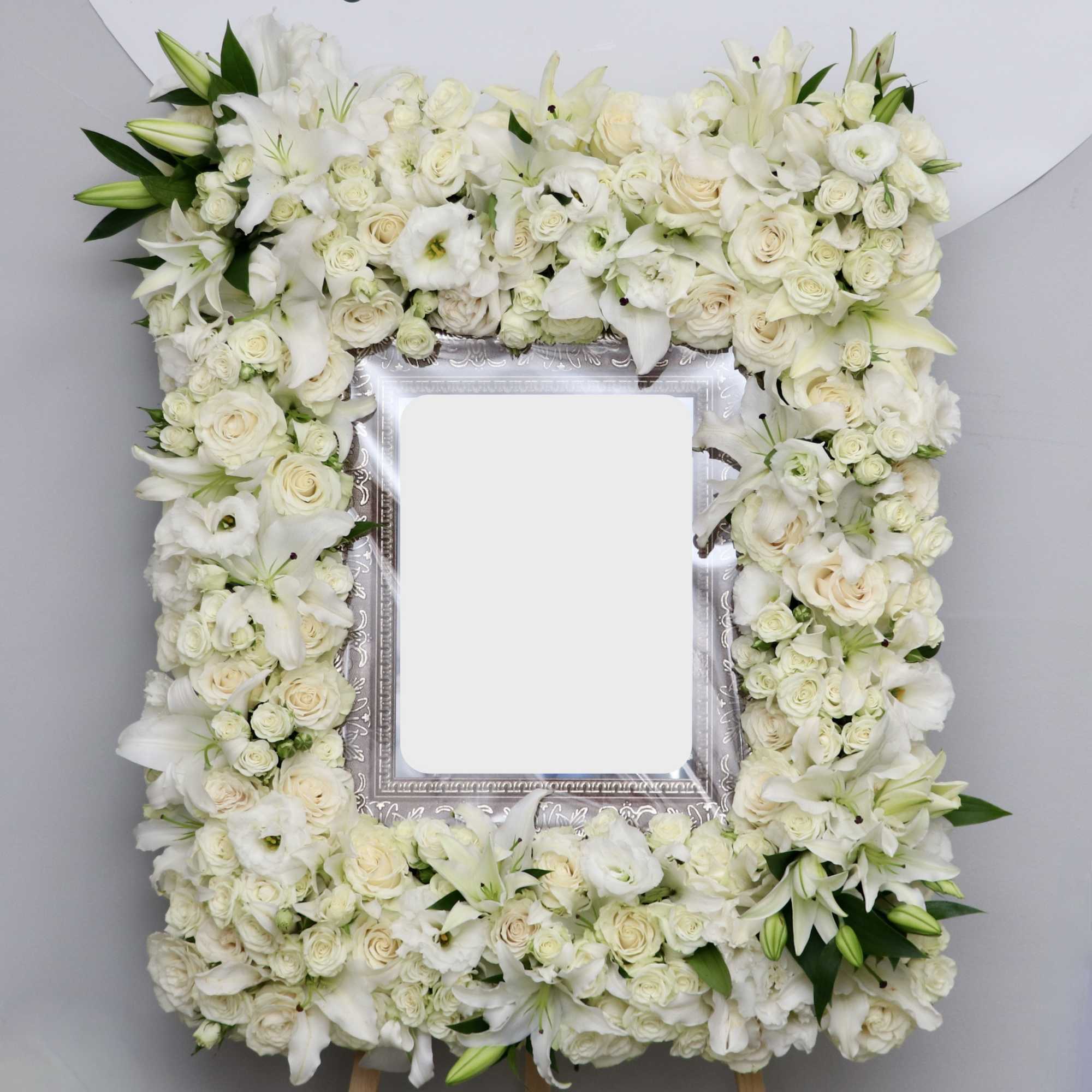 This white sympathy frame is made with a variety of white florals