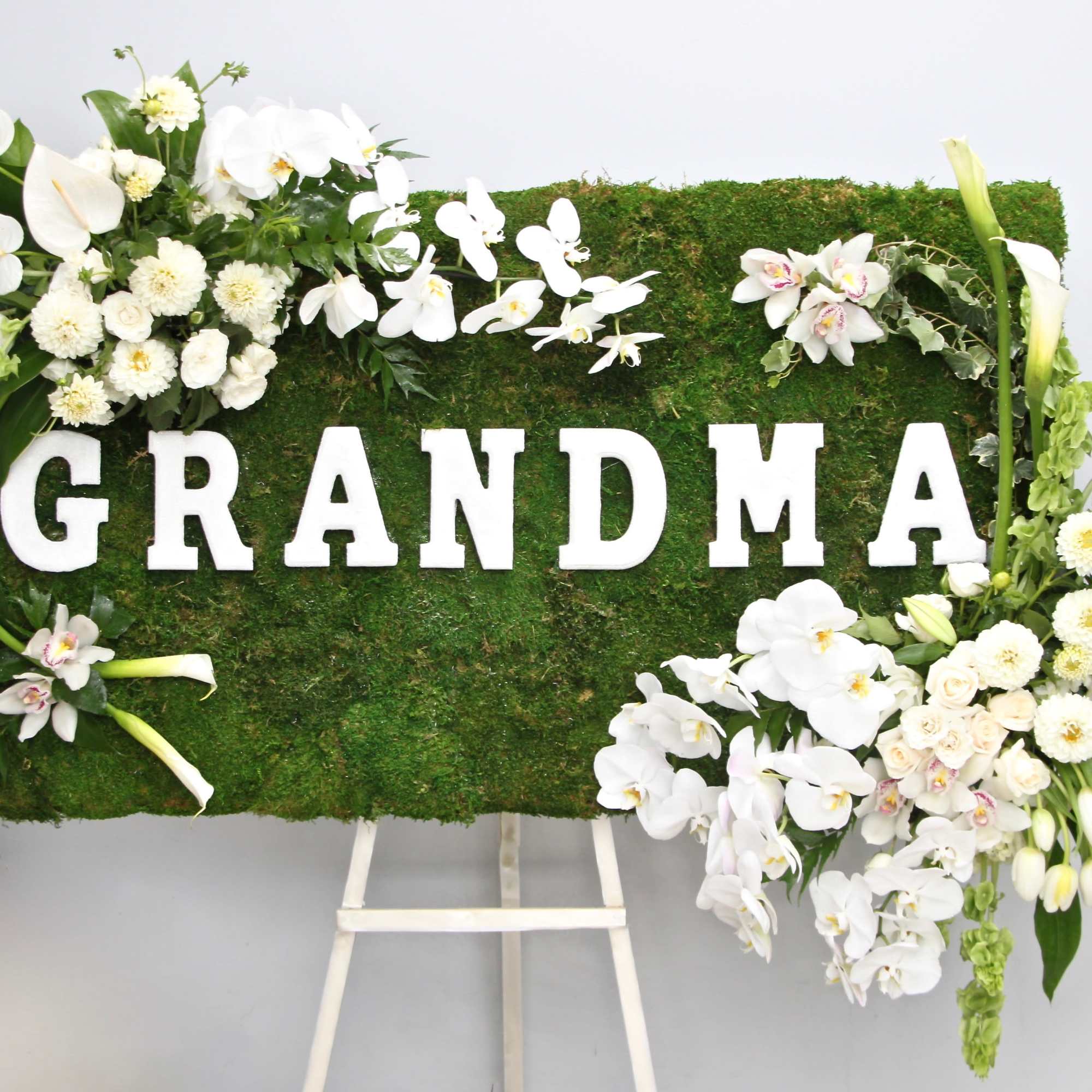 Covered in moss, this frame includes orchids, tulips, and season flowers. It