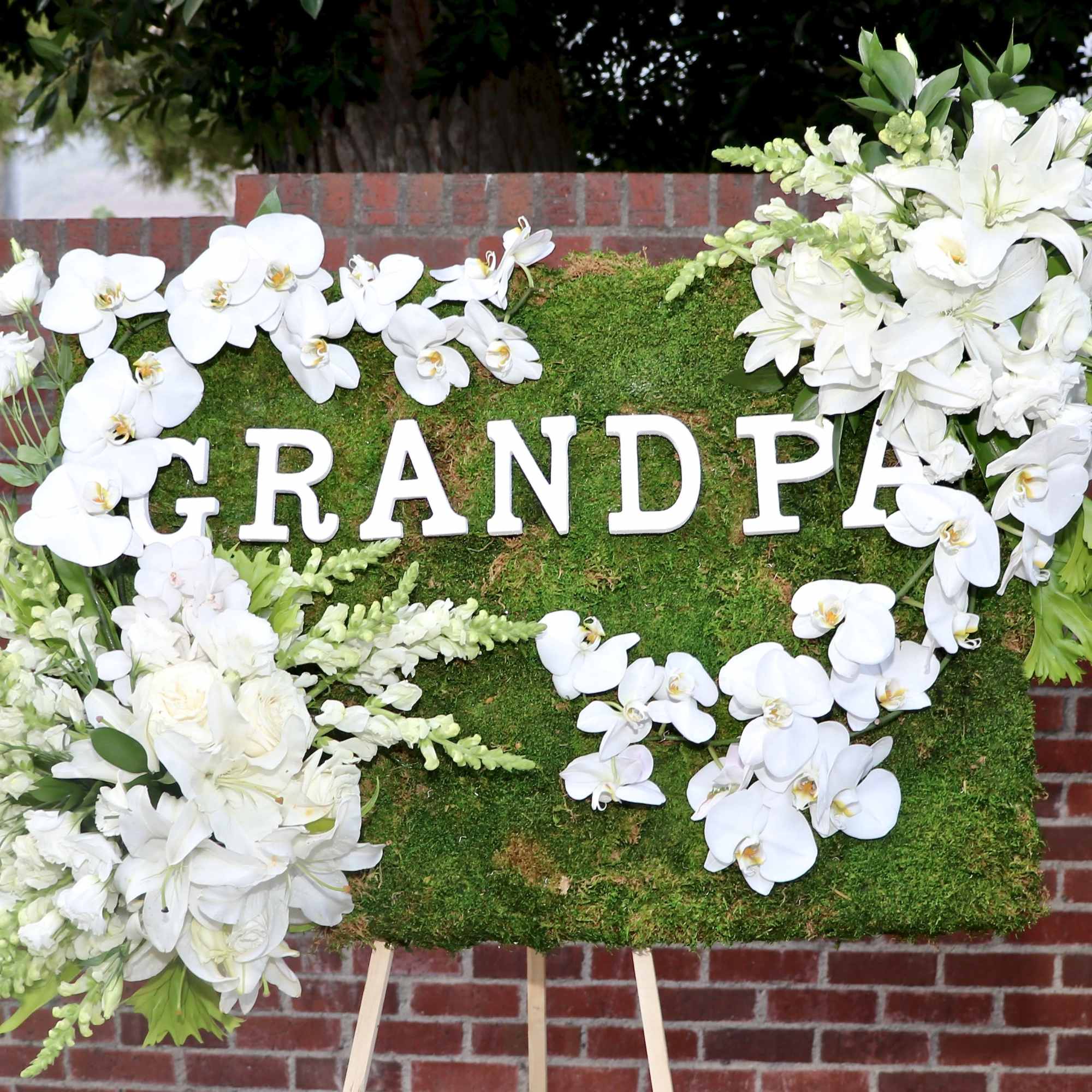 Covered in moss, this frame includes orchids, tulips, and season flowers. It