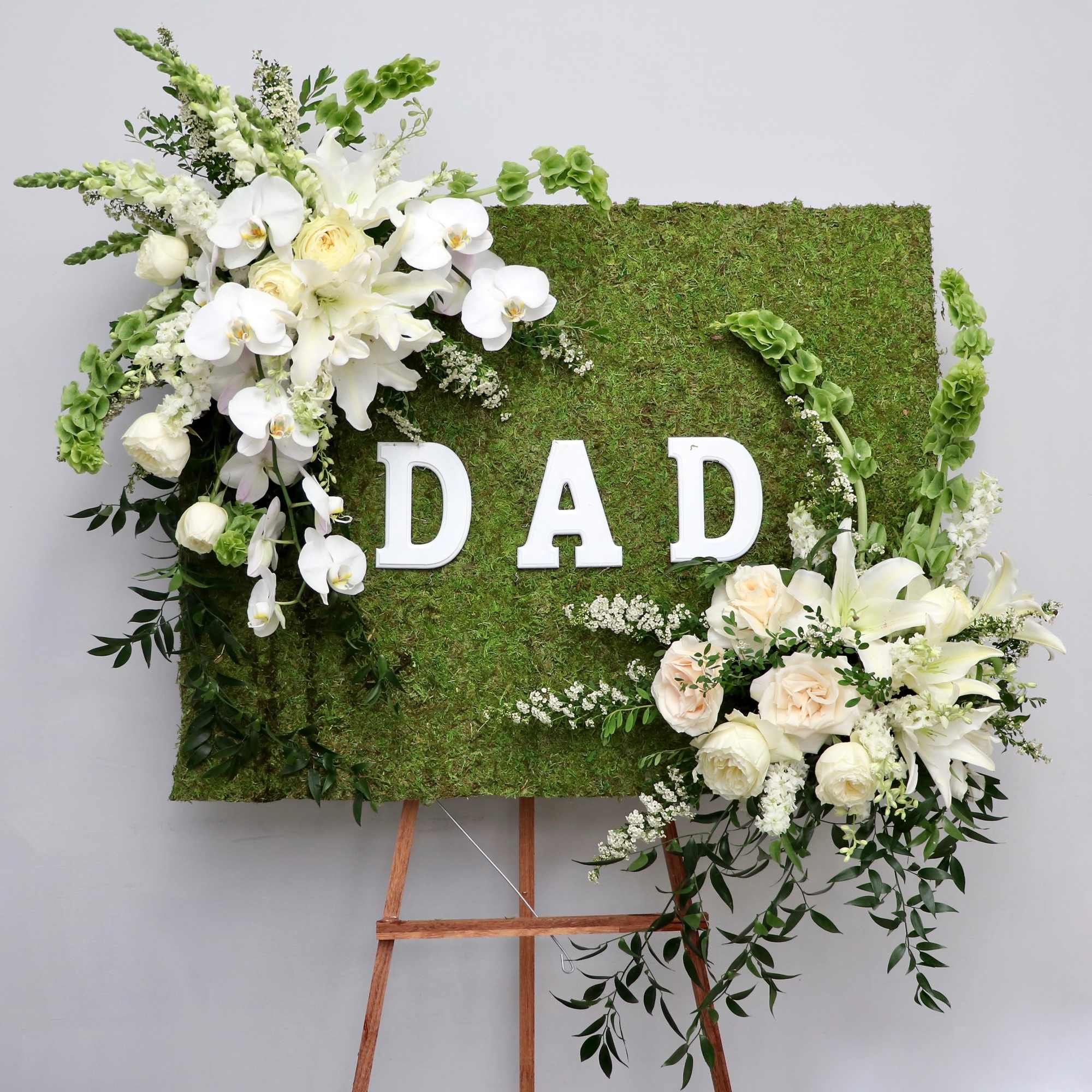 Covered in moss, this frame includes orchids, tulips, and season flowers. It