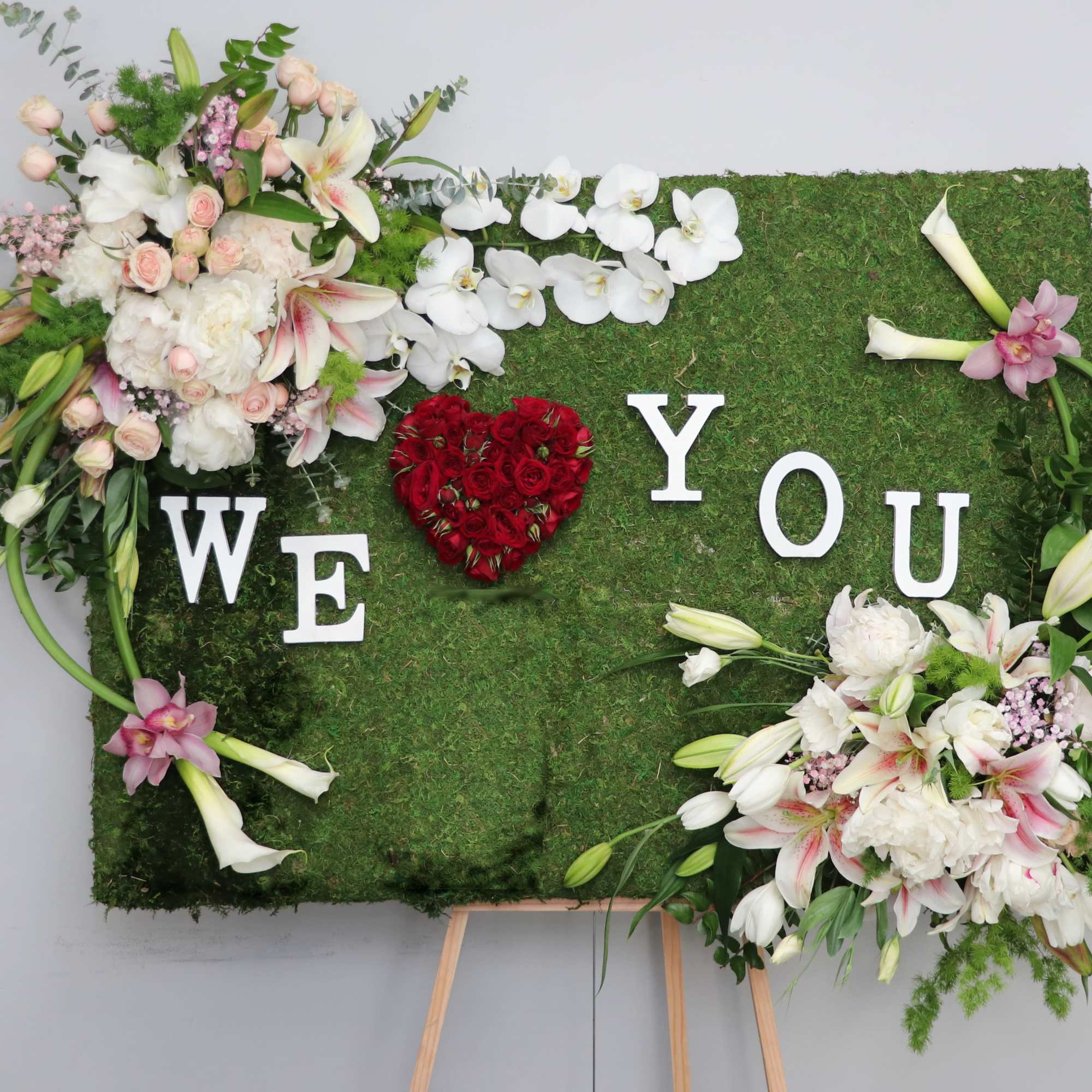 Covered in moss, this frame includes orchids, tulips, and season flowers. It