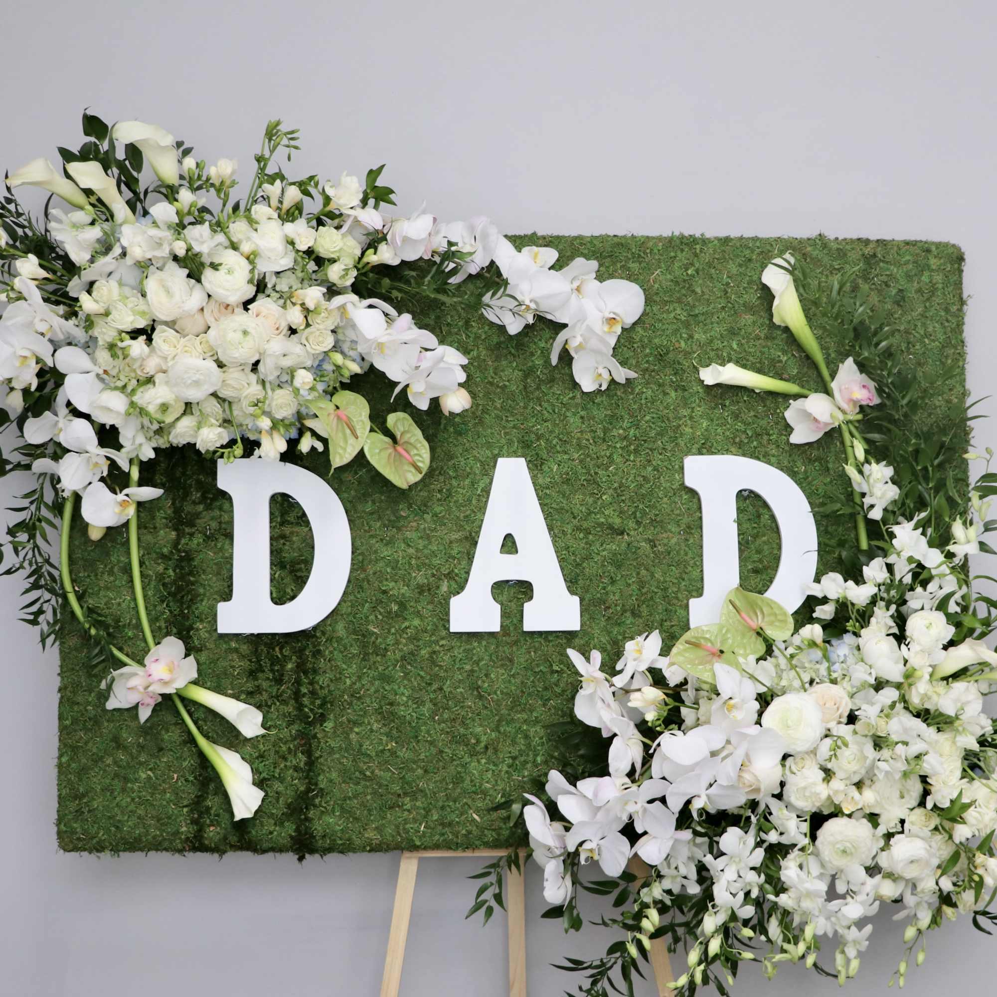 Covered in moss, this frame includes orchids, tulips, and season flowers. It