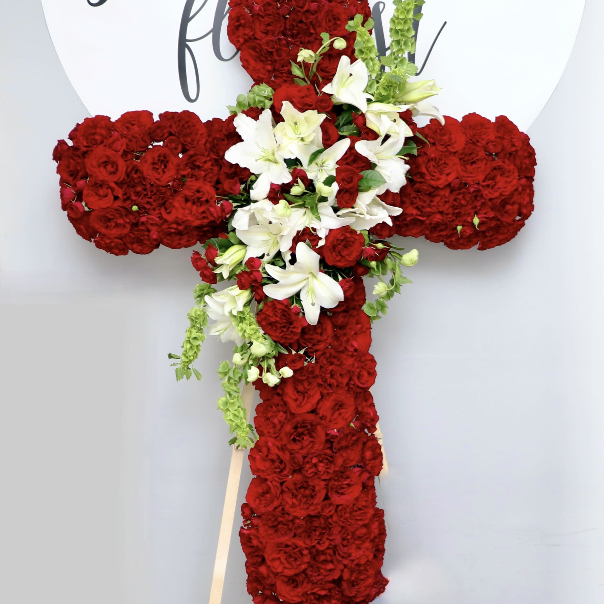 This cross contains red roses, stargazer lilies and calla lilies. We also