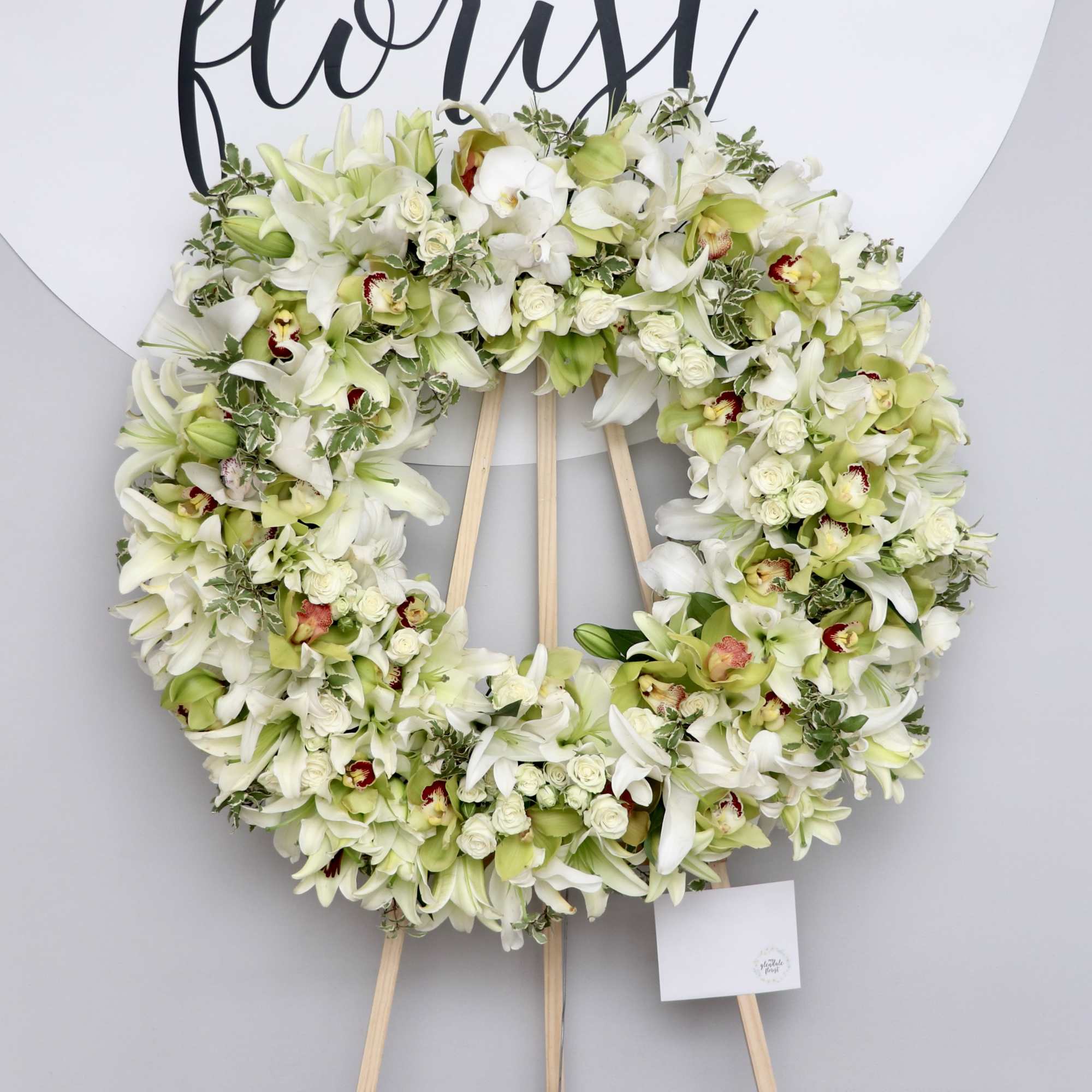 Lilies, Orchids, and spray roses make this the wreath anyone should get