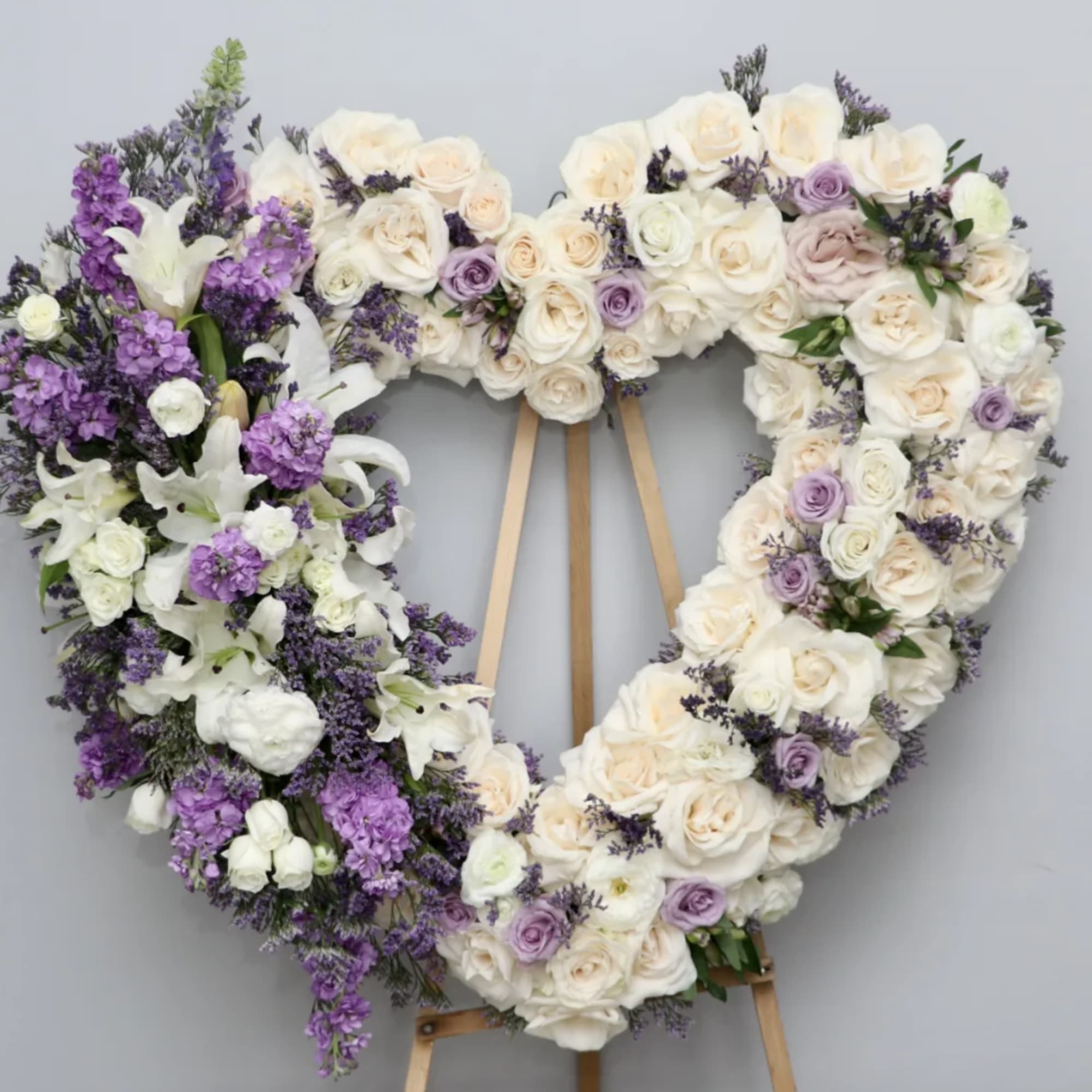 This heart includes white roses, lilies, and lavender roses. 

We include easel