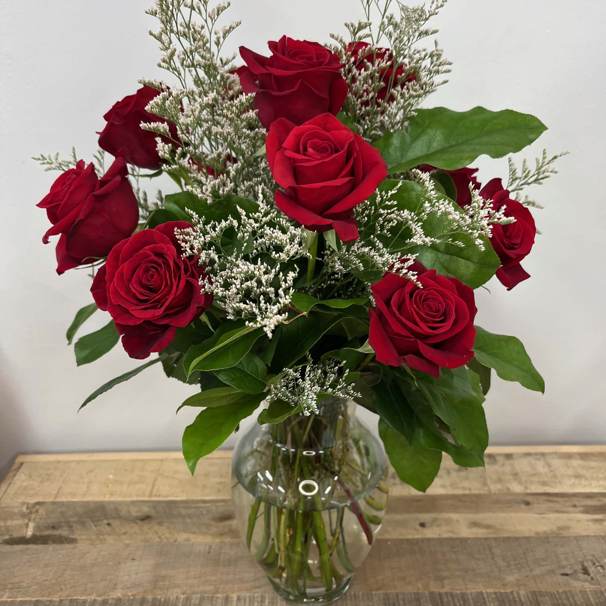 The Forest Whisper bouquet features delicate roses cradled in a rounded glass