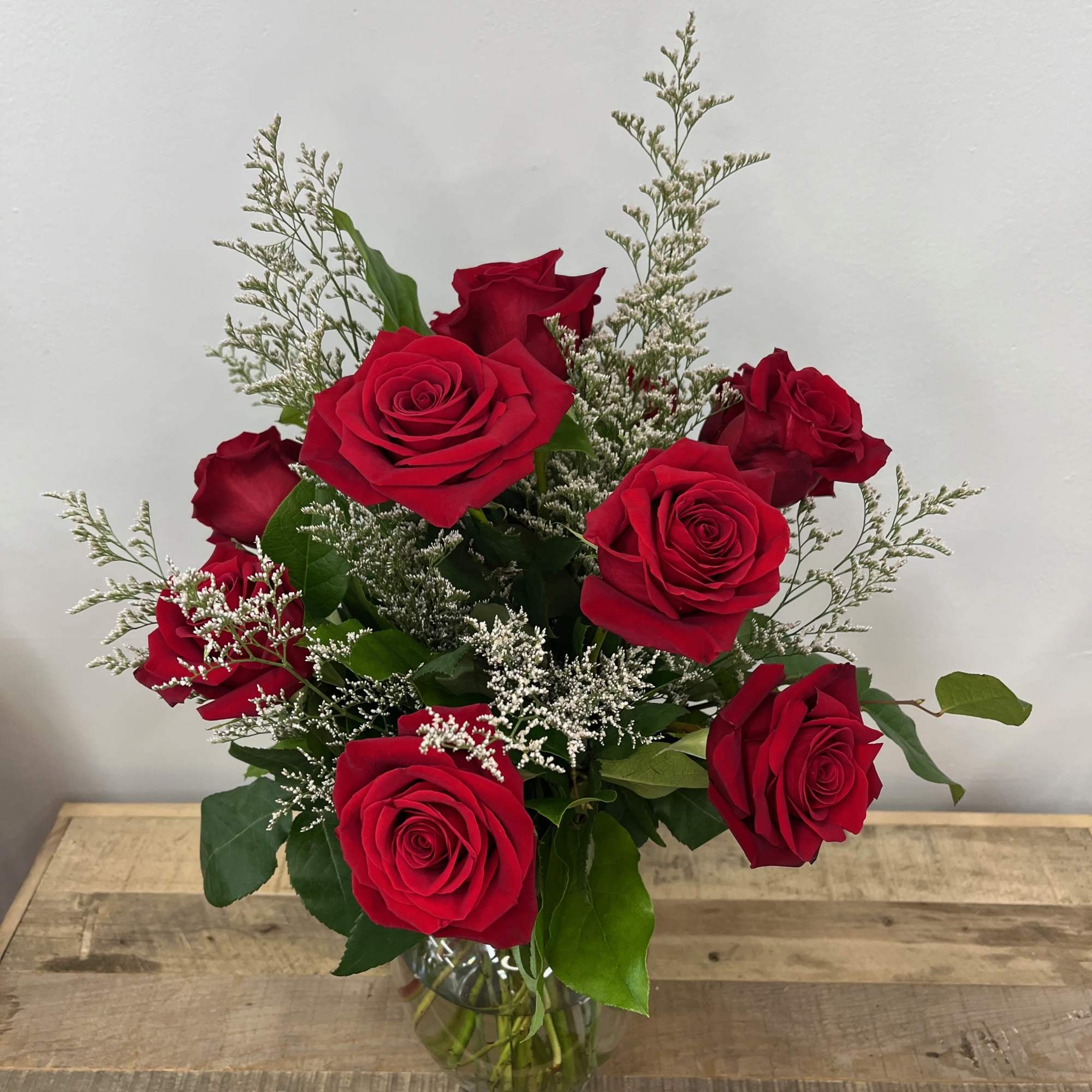 The Forest Whisper bouquet features delicate roses cradled in a rounded glass