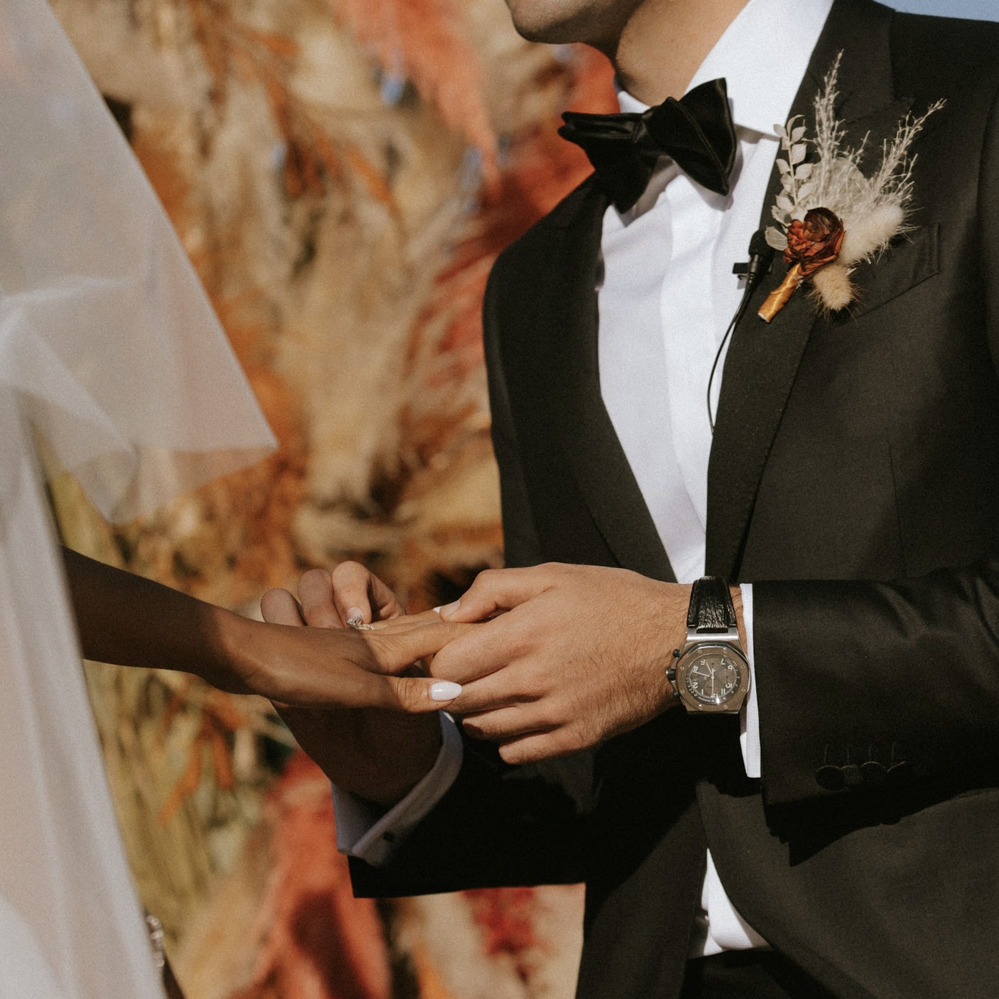 - Handcrafted groom boutonniere featuring rustic charm with moody oranges and peach