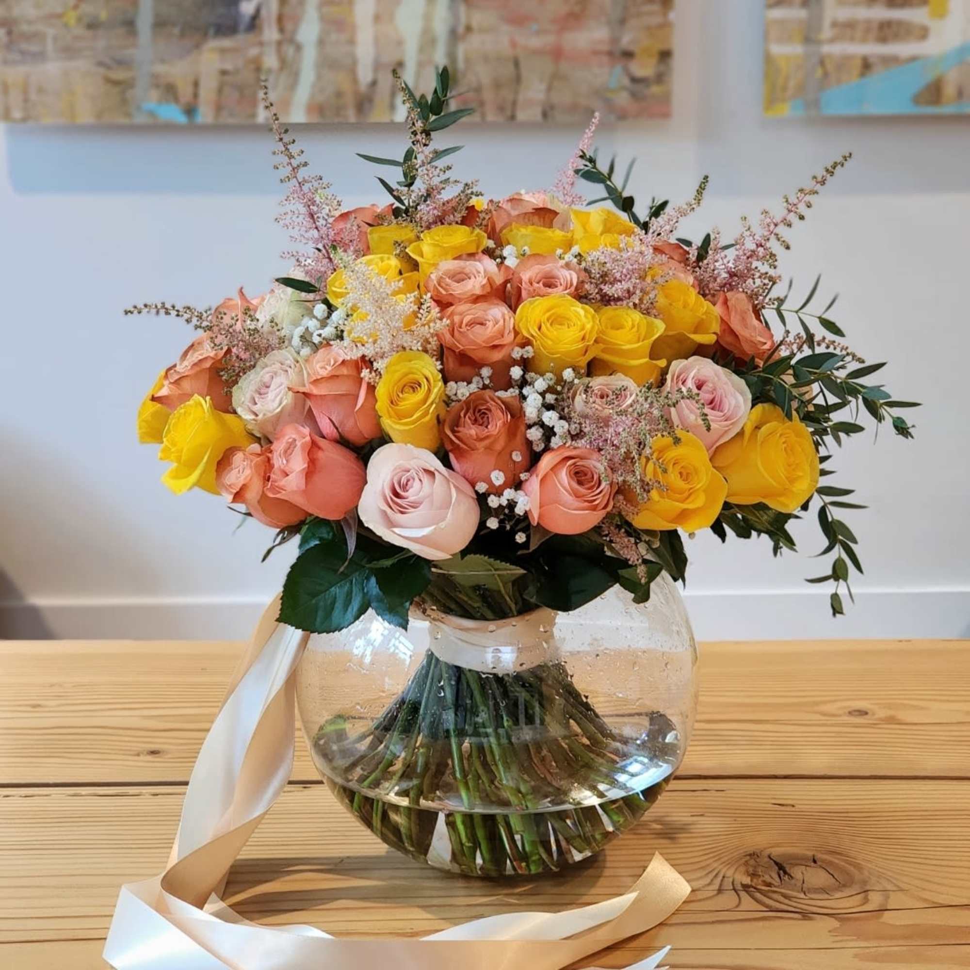 A vase filled with peach and yellow roses radiates elegance and warmth.The