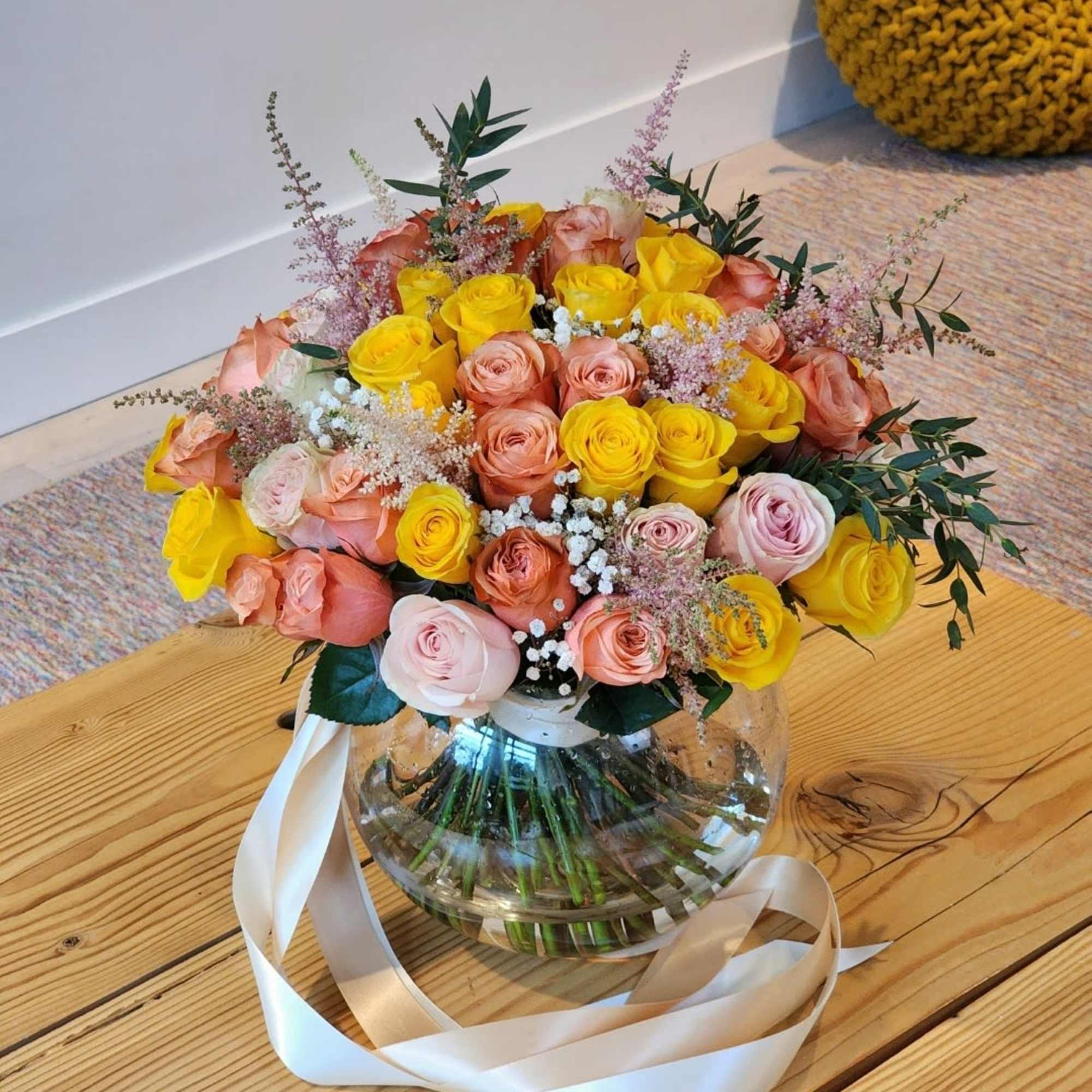A vase filled with peach and yellow roses radiates elegance and warmth.The
