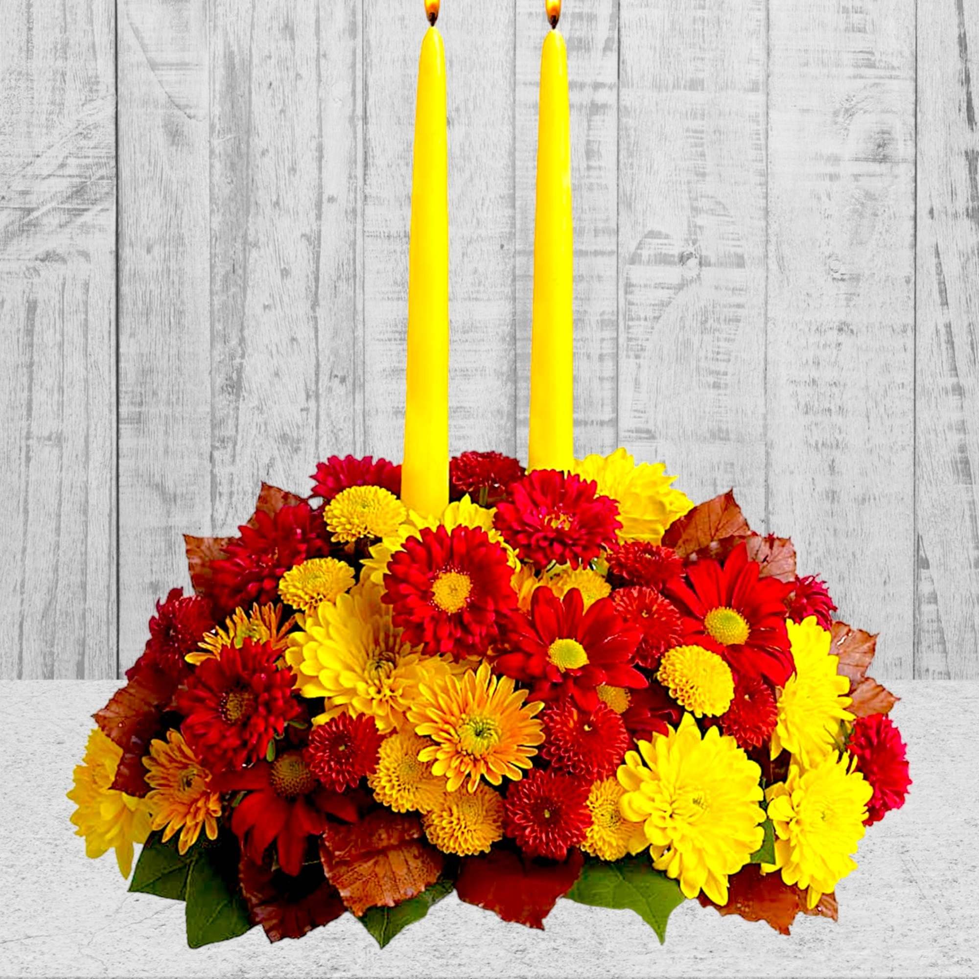 Happy yellow mums and a taper candle bring sunshine to your Thanksgiving