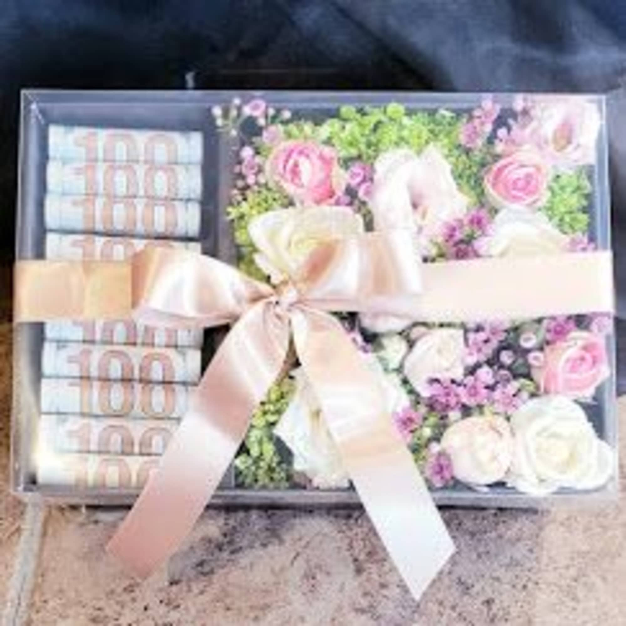 mix flowers with rolls of bill in box