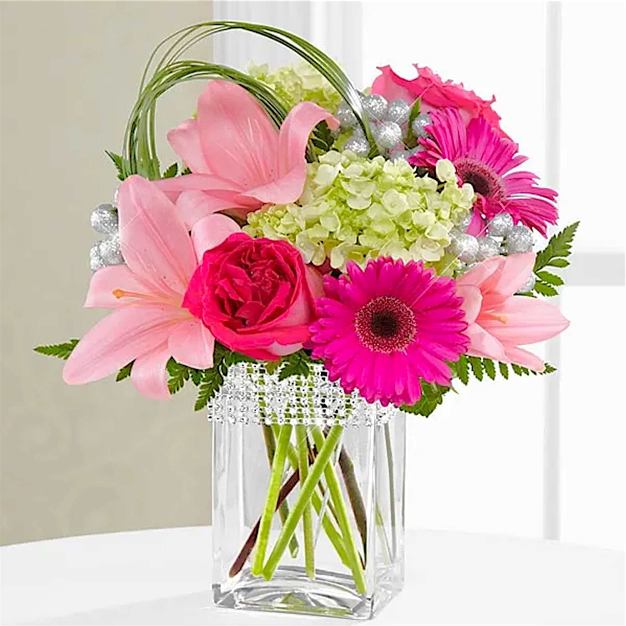 The Blooming Bliss arrangement showcases blushing blooms and definitive style to send