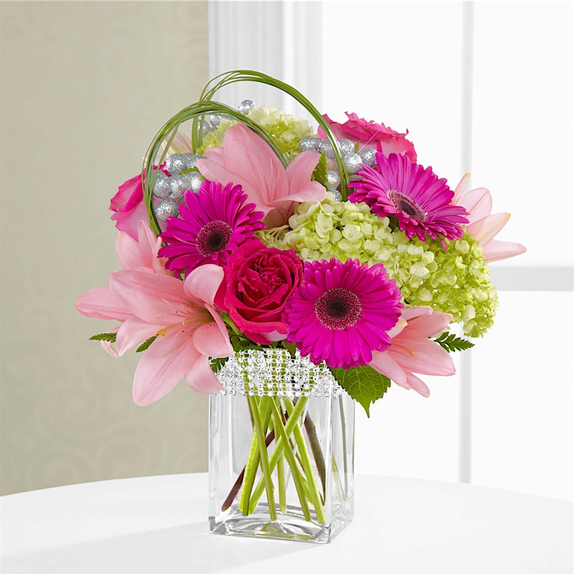 The Blooming Bliss arrangement showcases blushing blooms and definitive style to send