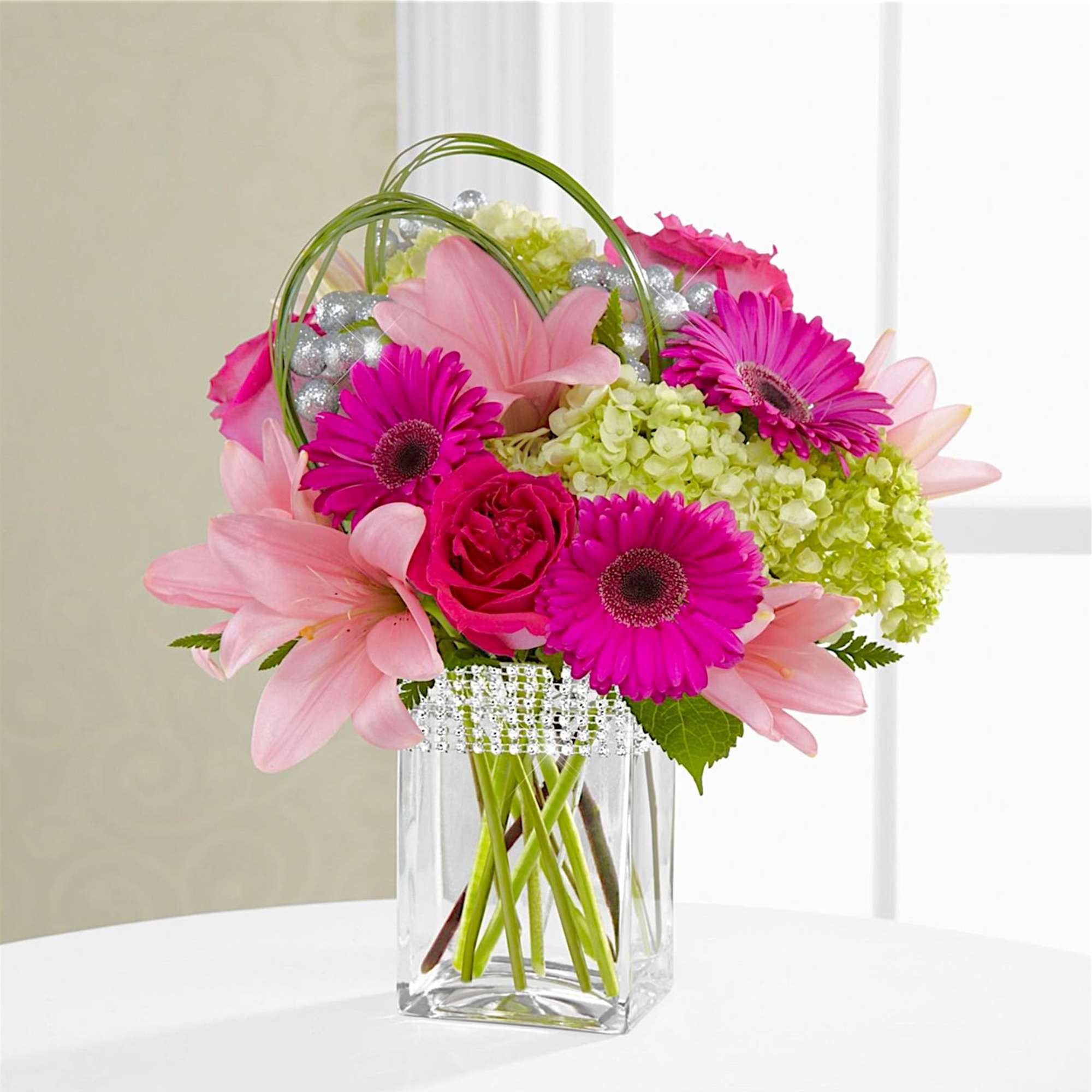 The Blooming Bliss arrangement showcases blushing blooms and definitive style to send