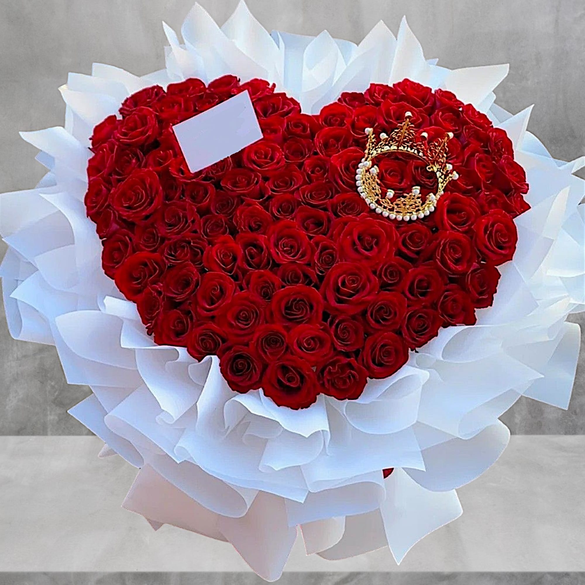A modern flower arrangement designed in a heart shape with 100 red
