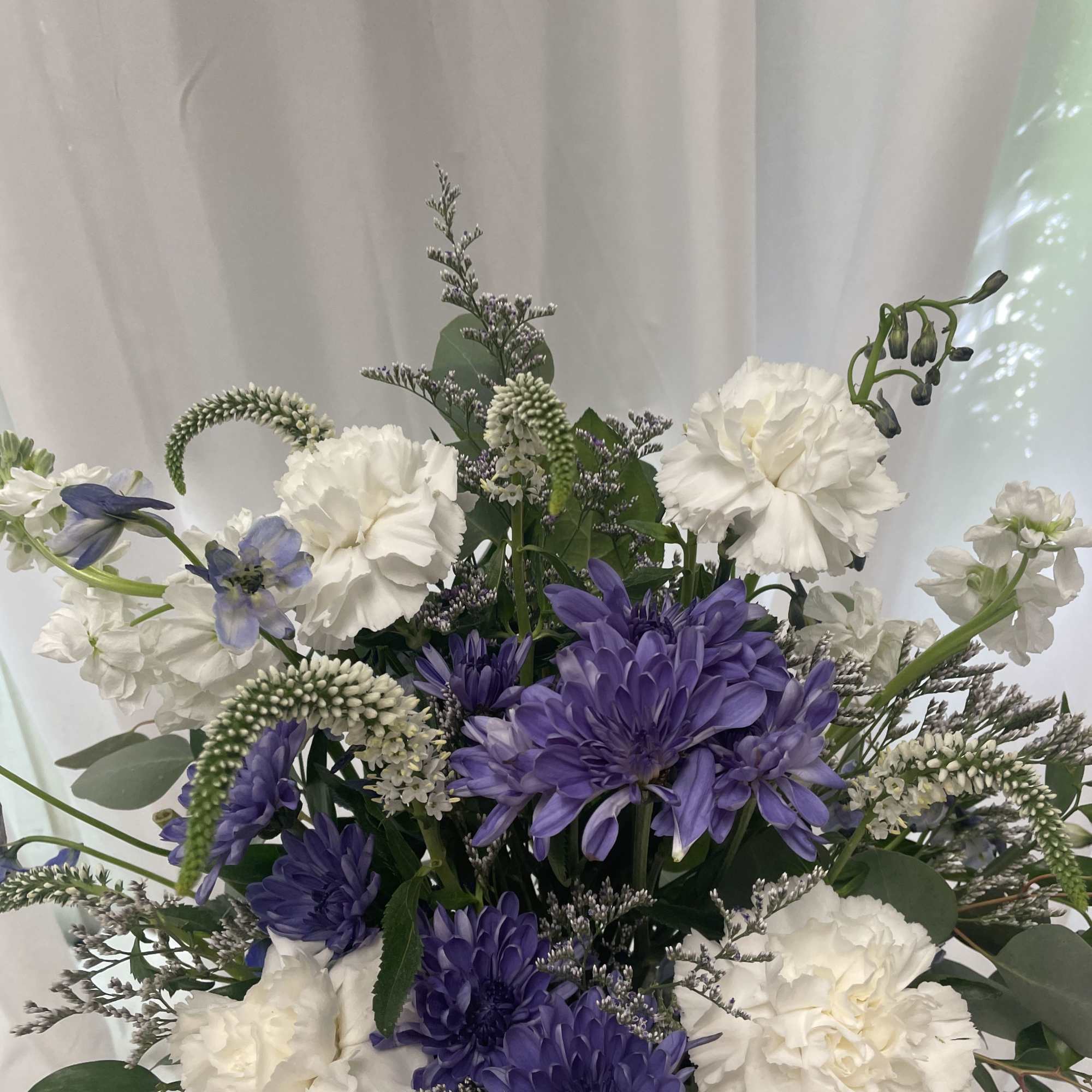 Blue and white arrangement in a reusable blue ceramic pitcher. 