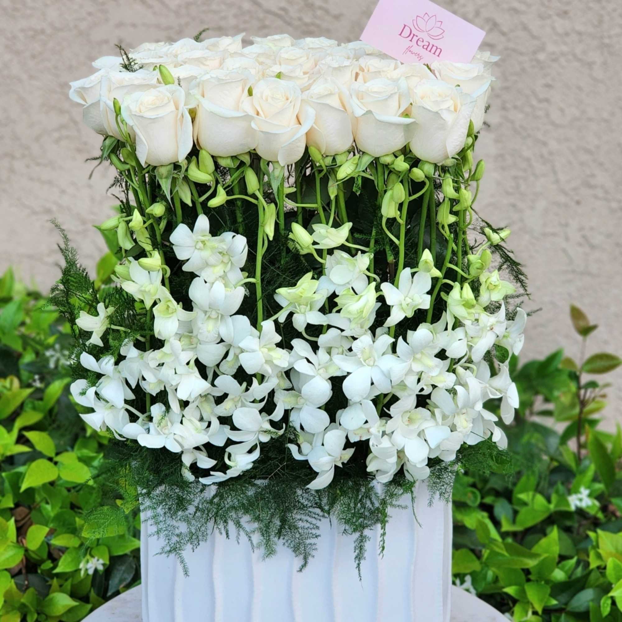 Enhance your decor with a tall ceramic white vase, featuring white roses