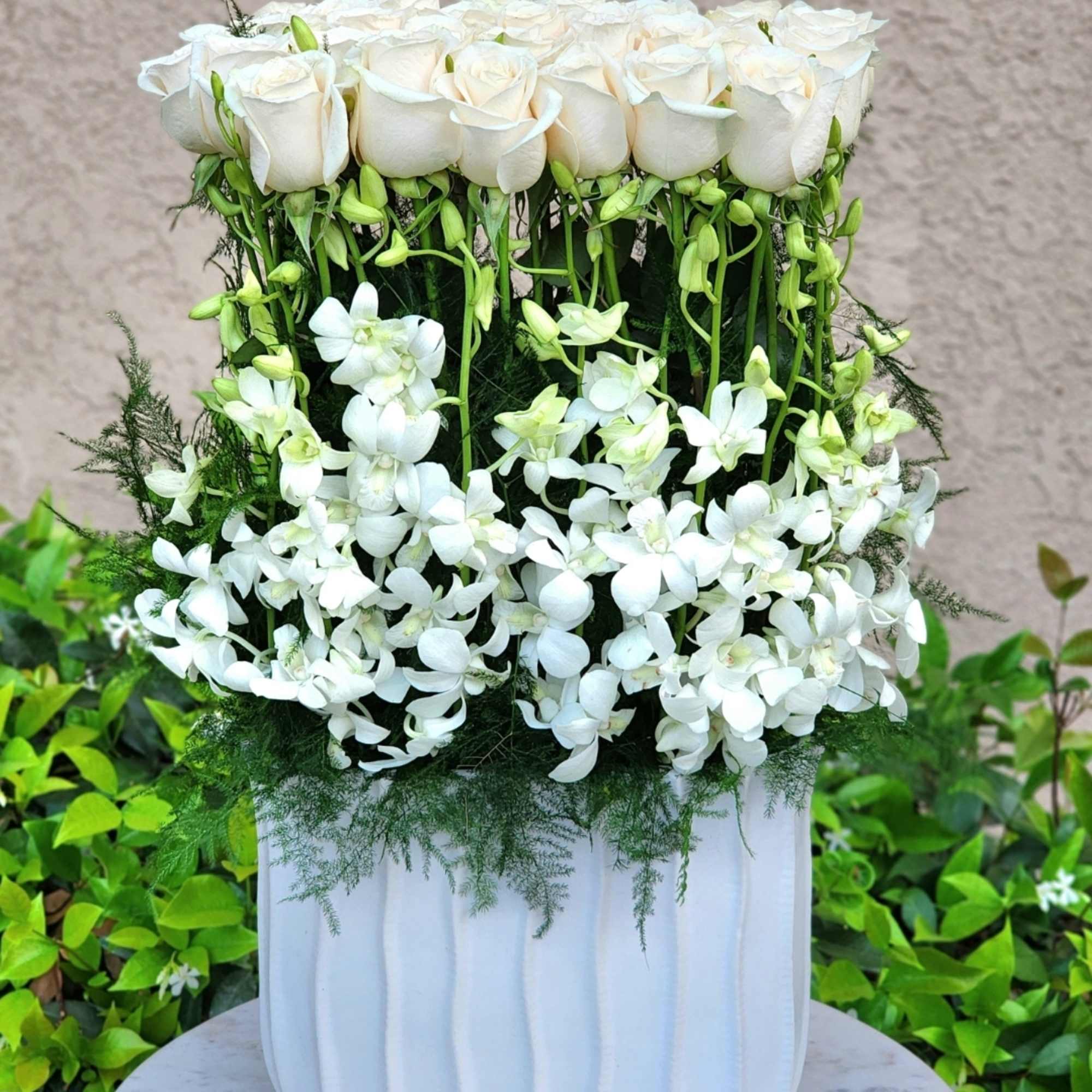Enhance your decor with a tall ceramic white vase, featuring white roses