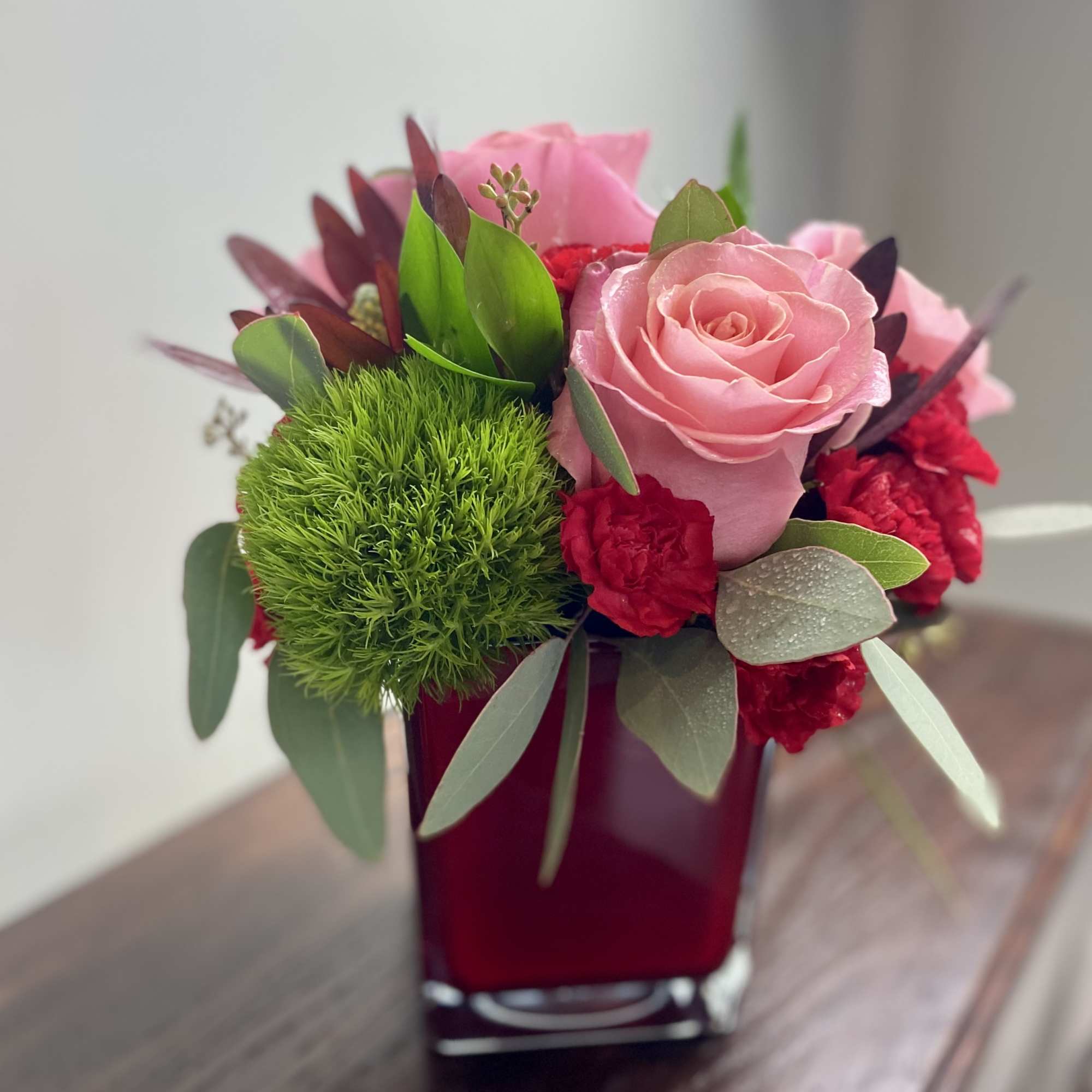 Beautiful arrangement of reds, pinks, and berries.  Includes red roses, pink