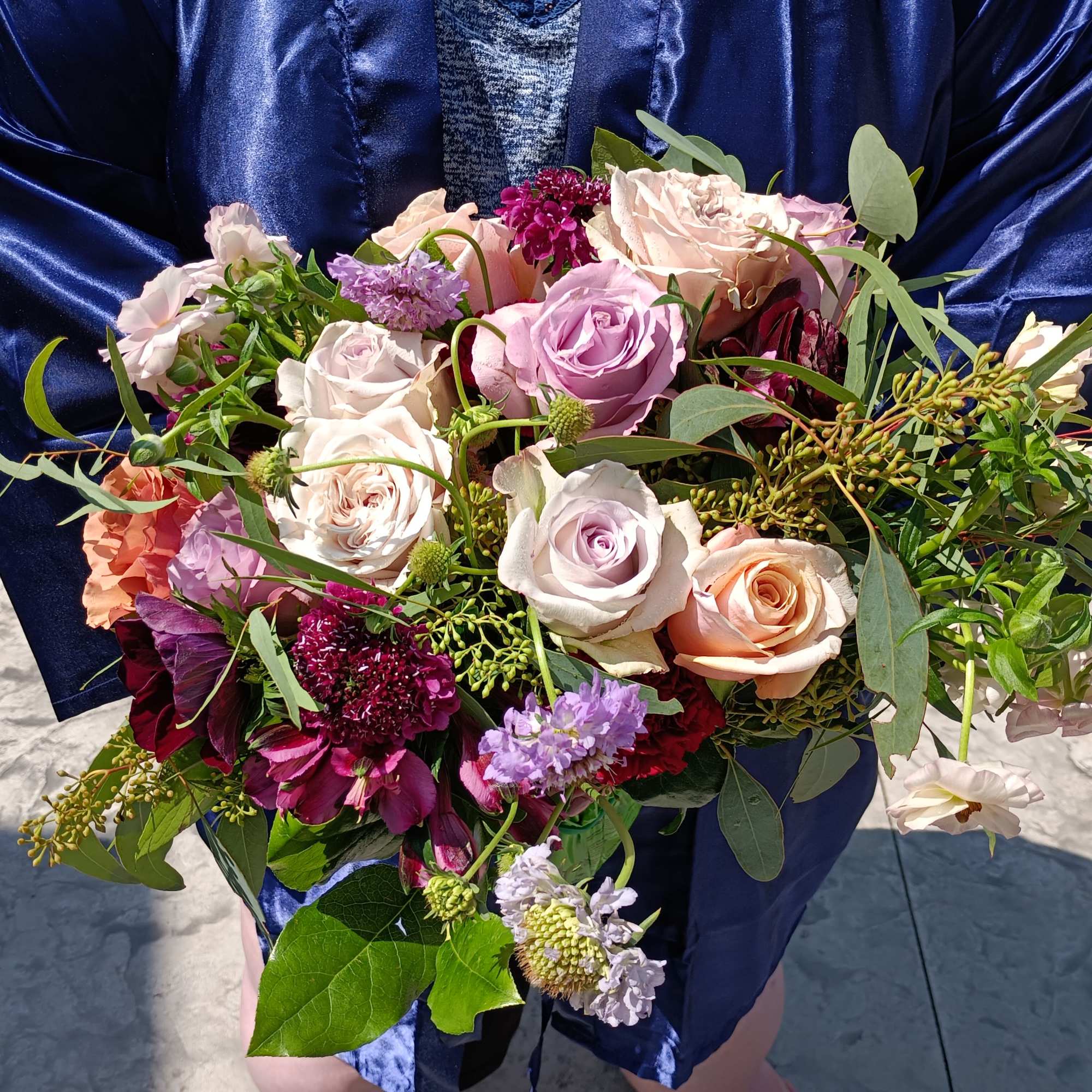 Beautiful rich mix of peach, blush, purple and burgundy roses ad other