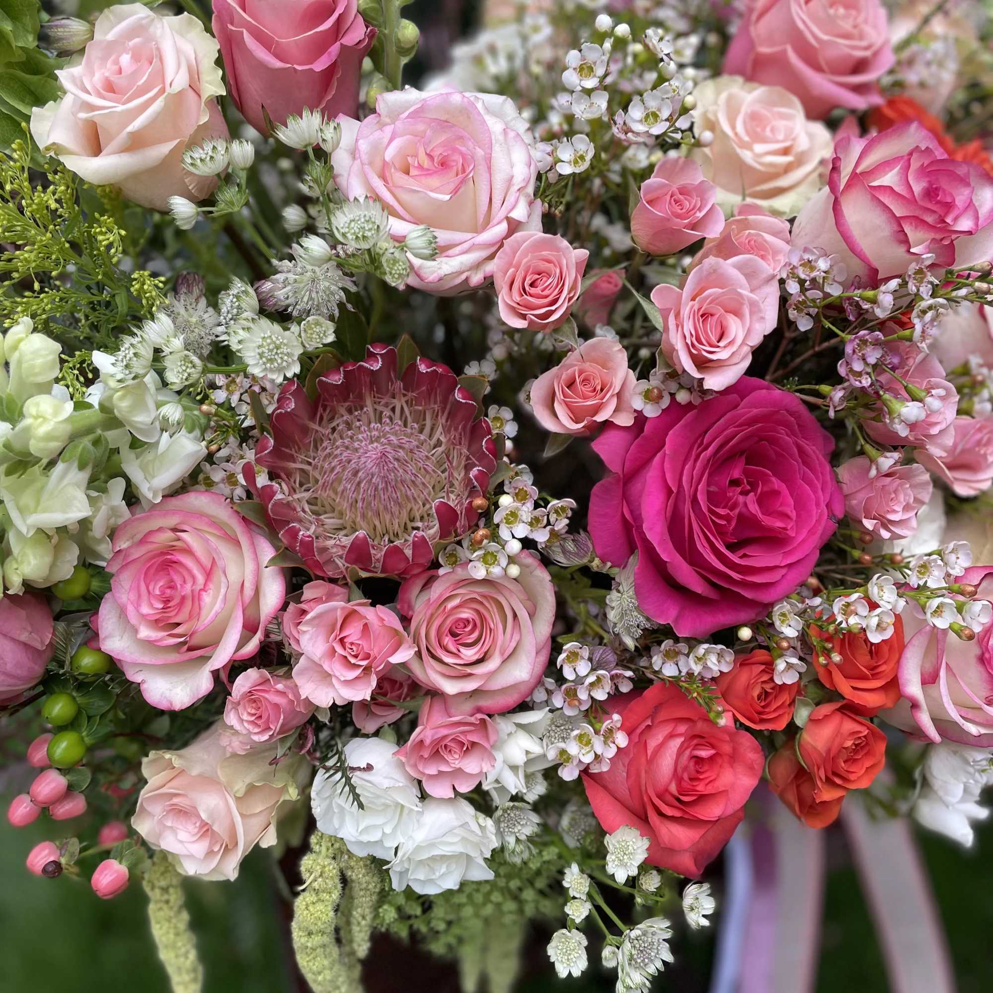A magnificent French basket arrangement of oversized pink and peach-colored roses is
