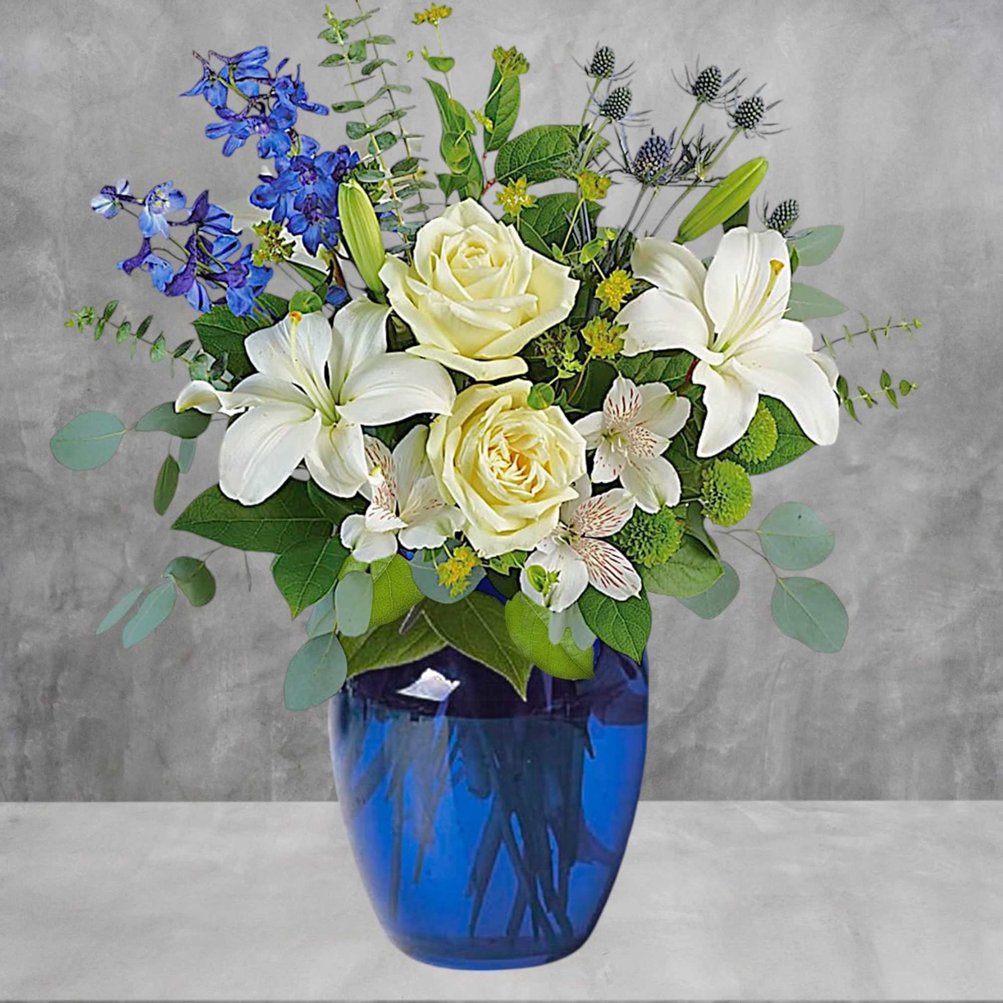 With its deep cobalt glass vase and white blooms, this soothing bouquet