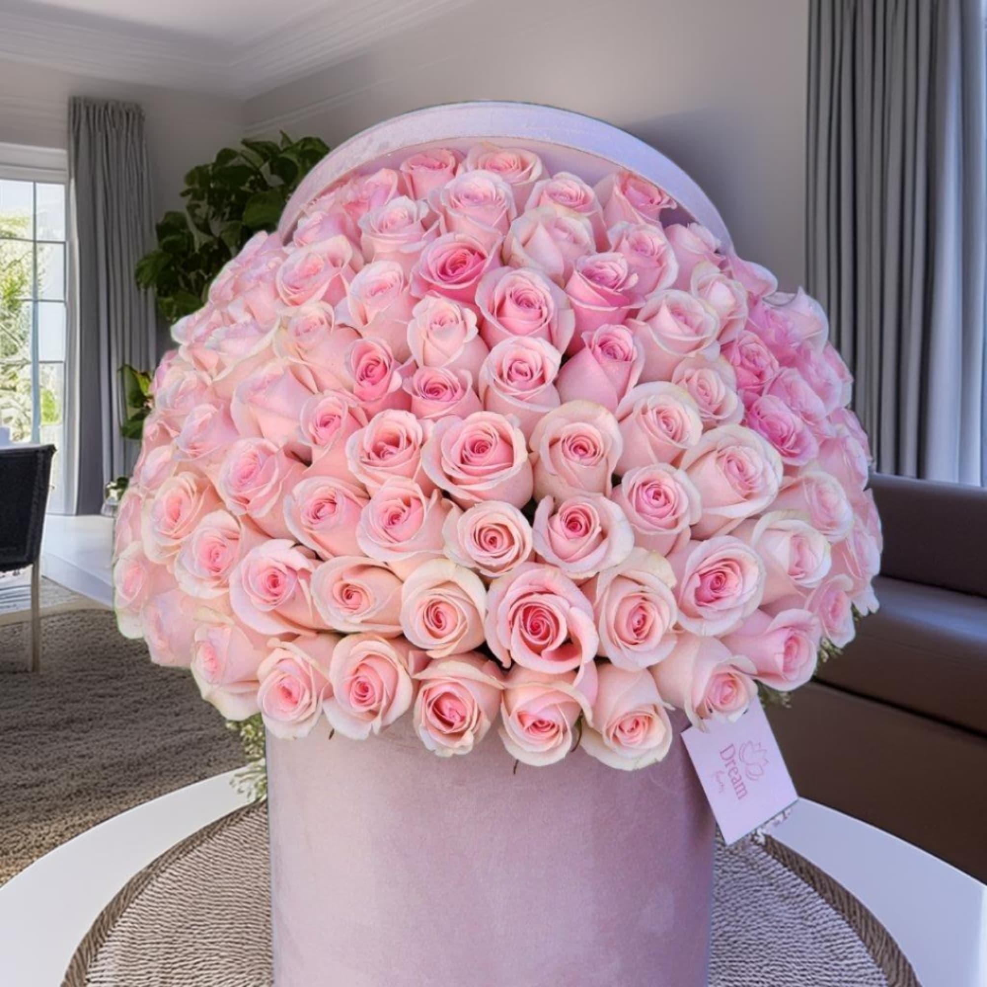 Fresh pink roses arranged in a hatbox exude elegance and charm. The