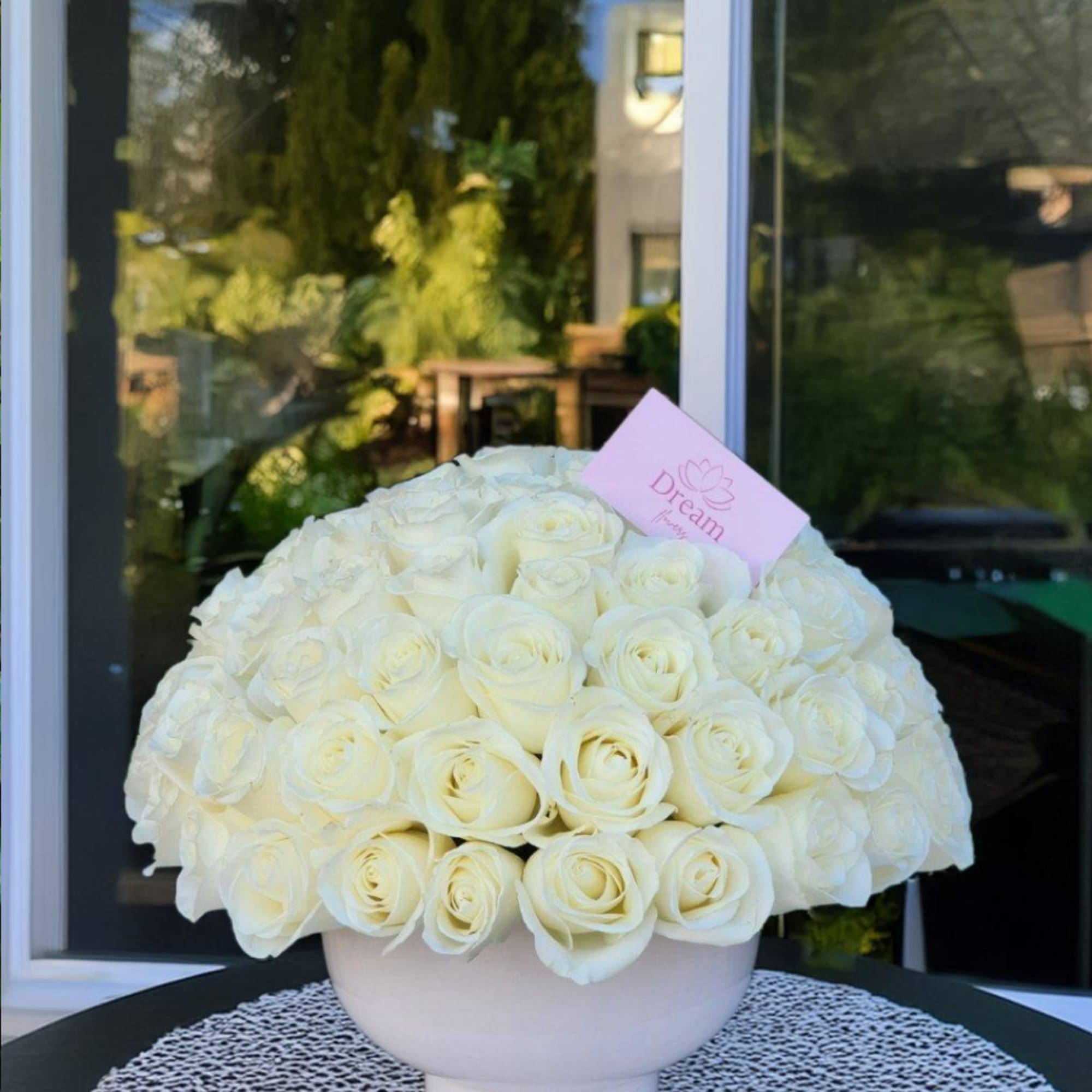 Pure elegance captured in a timeless arrangement: pristine white roses delicately cradled