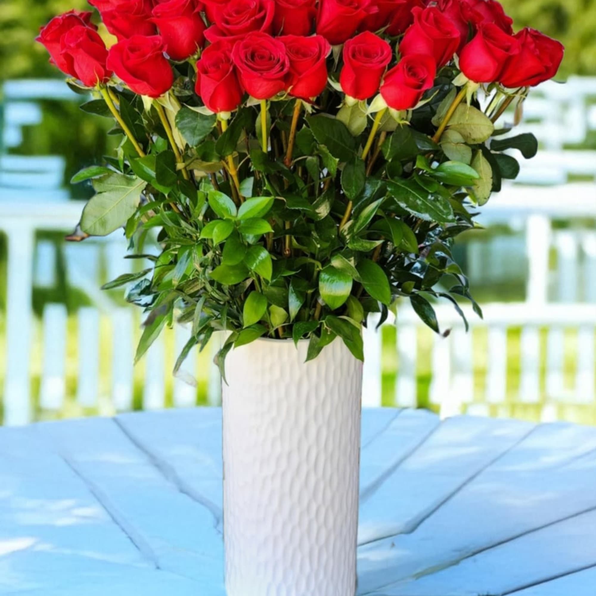 Classic arrangement of red roses in white tall vases is perfect for