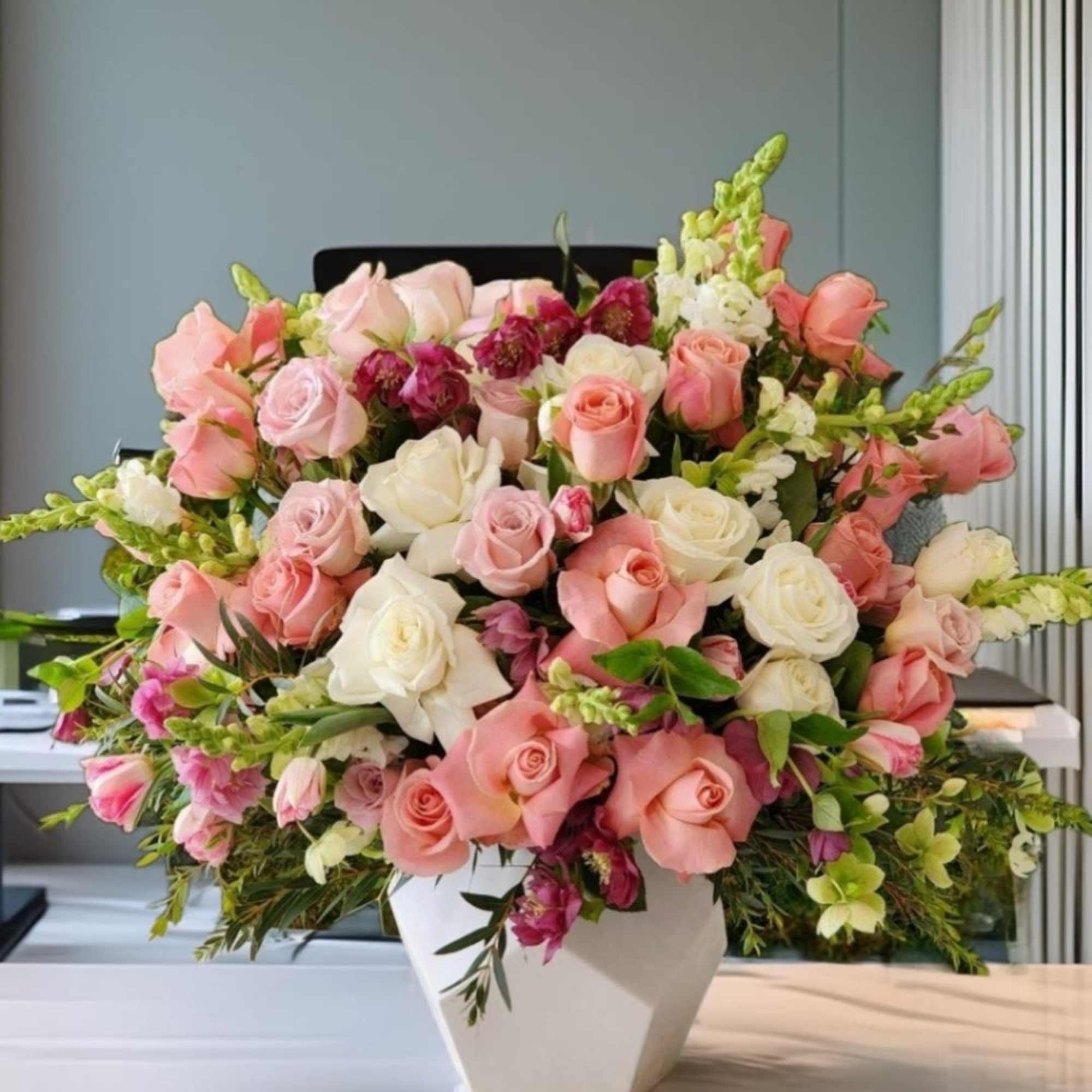 Delicate and light arrangement in a white ceramic vase with pink and